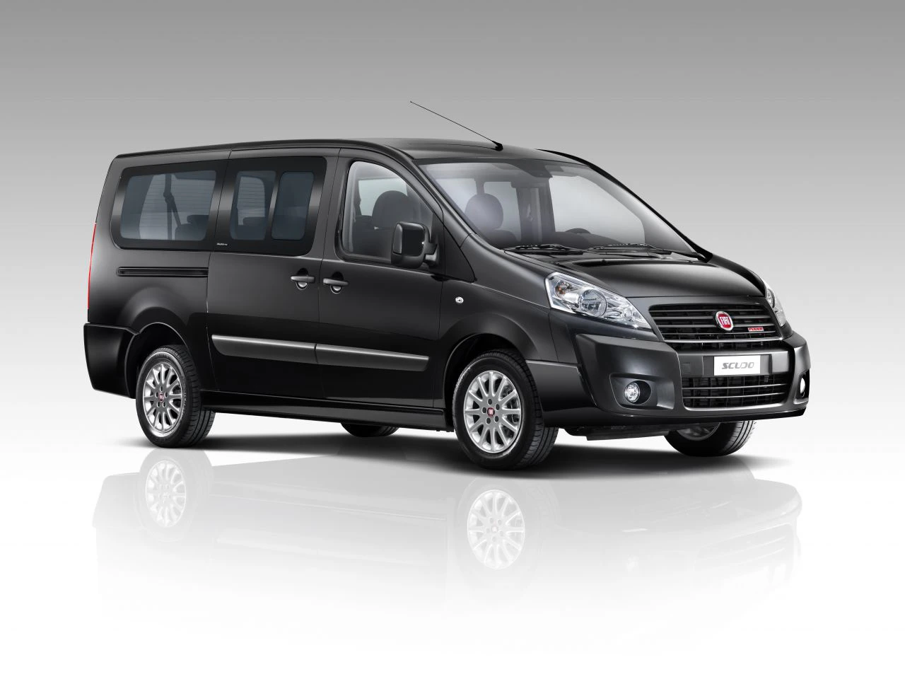 Schwarzer Fiat Scudo Kleinbus vor grauem Hintergrund, seitliche Ansicht.
