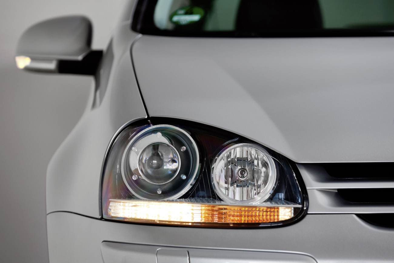 Nahaufnahme eines silbernen Autos mit zwei Scheinwerfern auf der linken Seite, modernem Design und einem blinker.