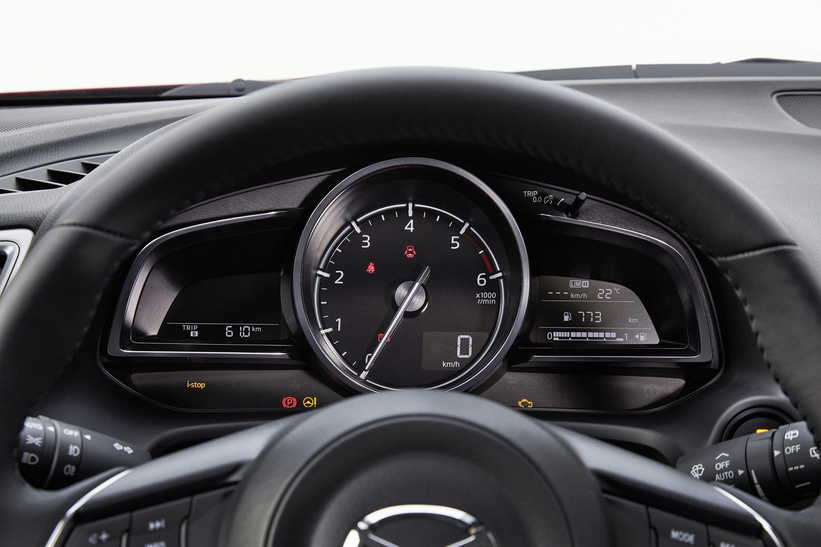 Lenkrad und Tachometer eines Autos, Anzeige von Geschwindigkeit und Temperatur. Schwarzes Armaturenbrett mit Bedienknöpfen.