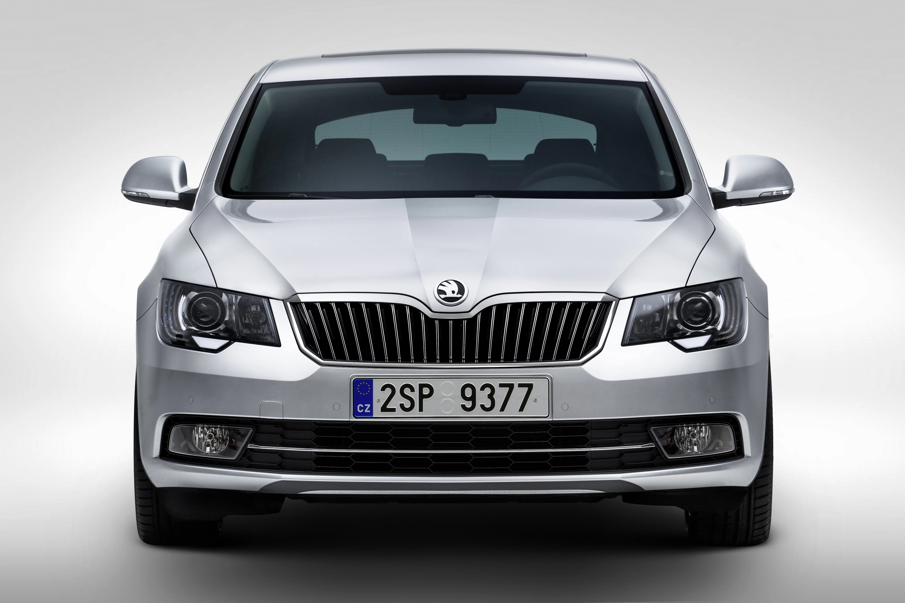 Silberner Skoda Superb, Frontansicht, mit charakteristischen Scheinwerfern und markantem Kühlergrill, EU-Kennzeichen sichtbar.