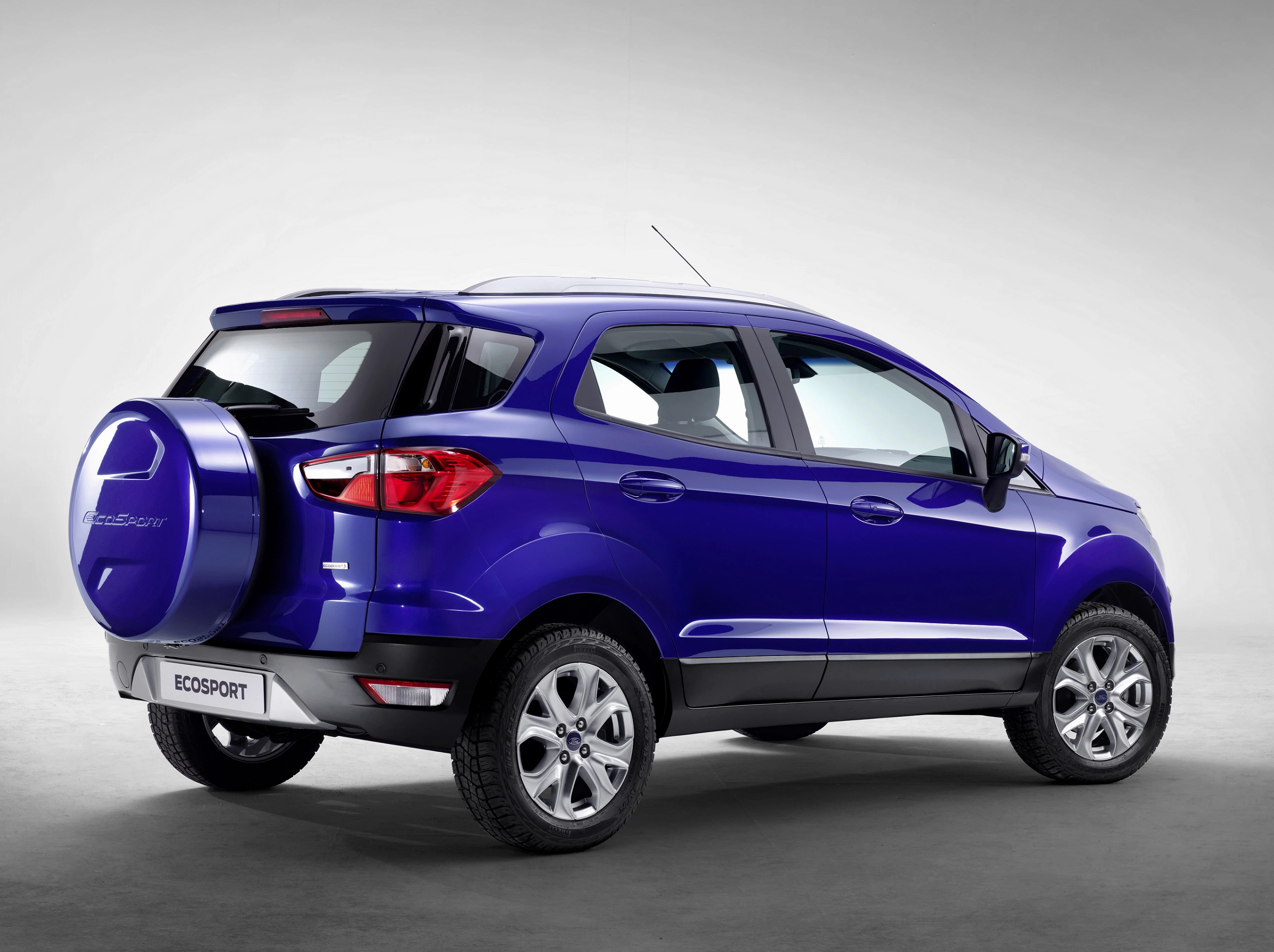Blauer SUV der Marke Ford Ecosport, Rückansicht, auf grauem Hintergrund fotografiert. Ersatzrad an der Heckklappe.