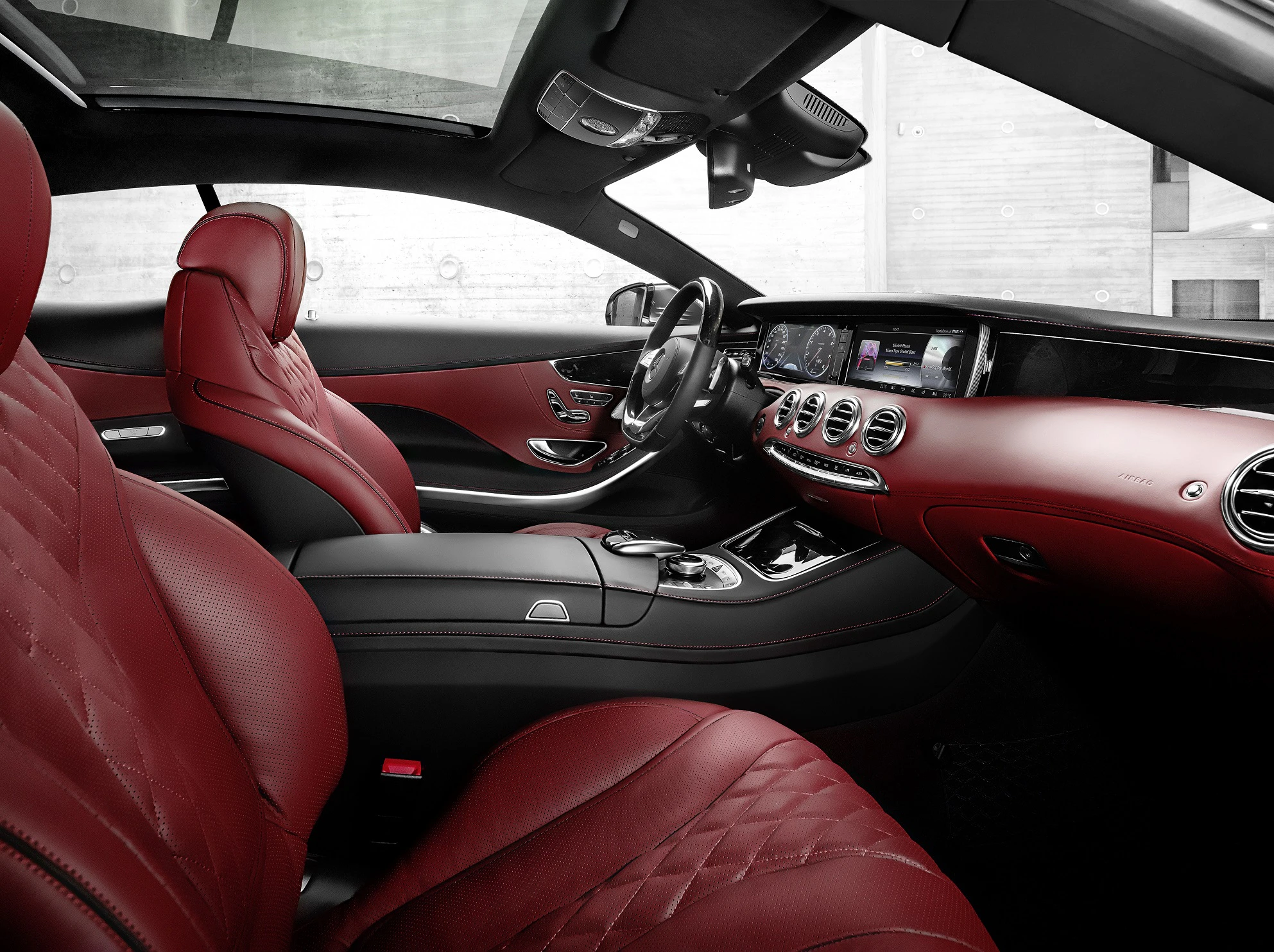 Luxuriöser Auto-Innenraum mit roten Ledersitzen, hochmodernem Armaturenbrett und eleganter Mittelkonsole, die stilvolle Raffinesse ausstrahlen.