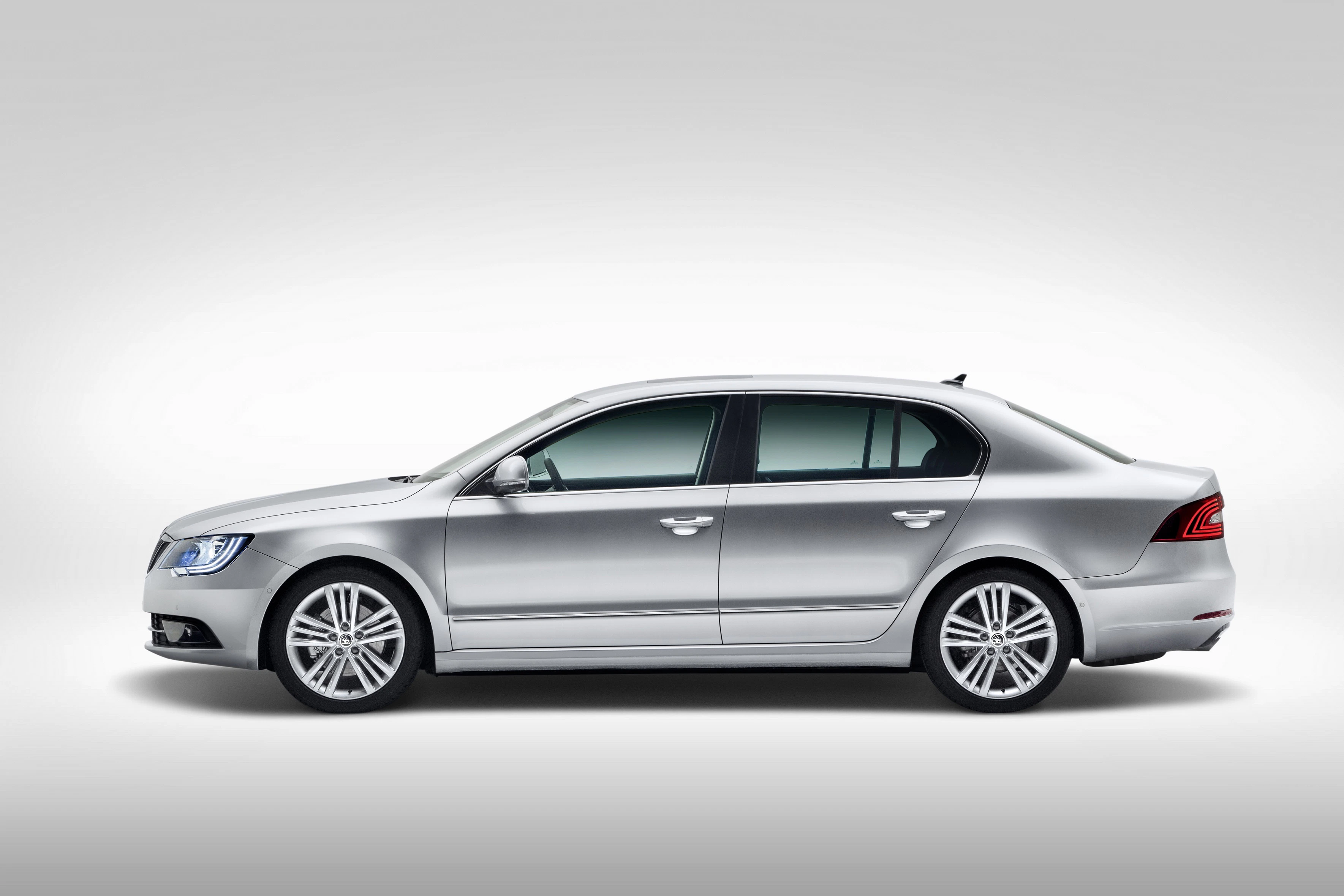 Silberner Limousine mit vier Türen, im Profil auf grauem Hintergrund abgebildet. Elegantes und modernes Design.