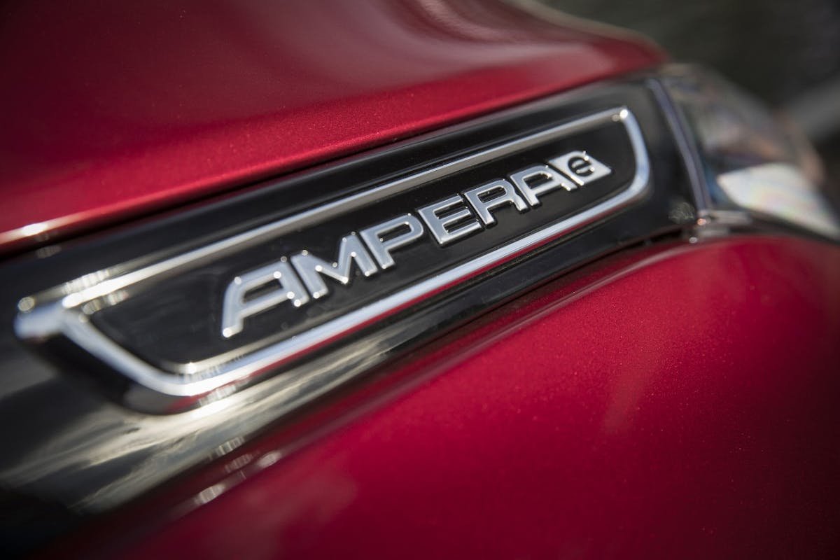 Nahaufnahme eines roten Autos mit dem Emblem "AMPERA e". glänzende Oberfläche mit Reflexionen.