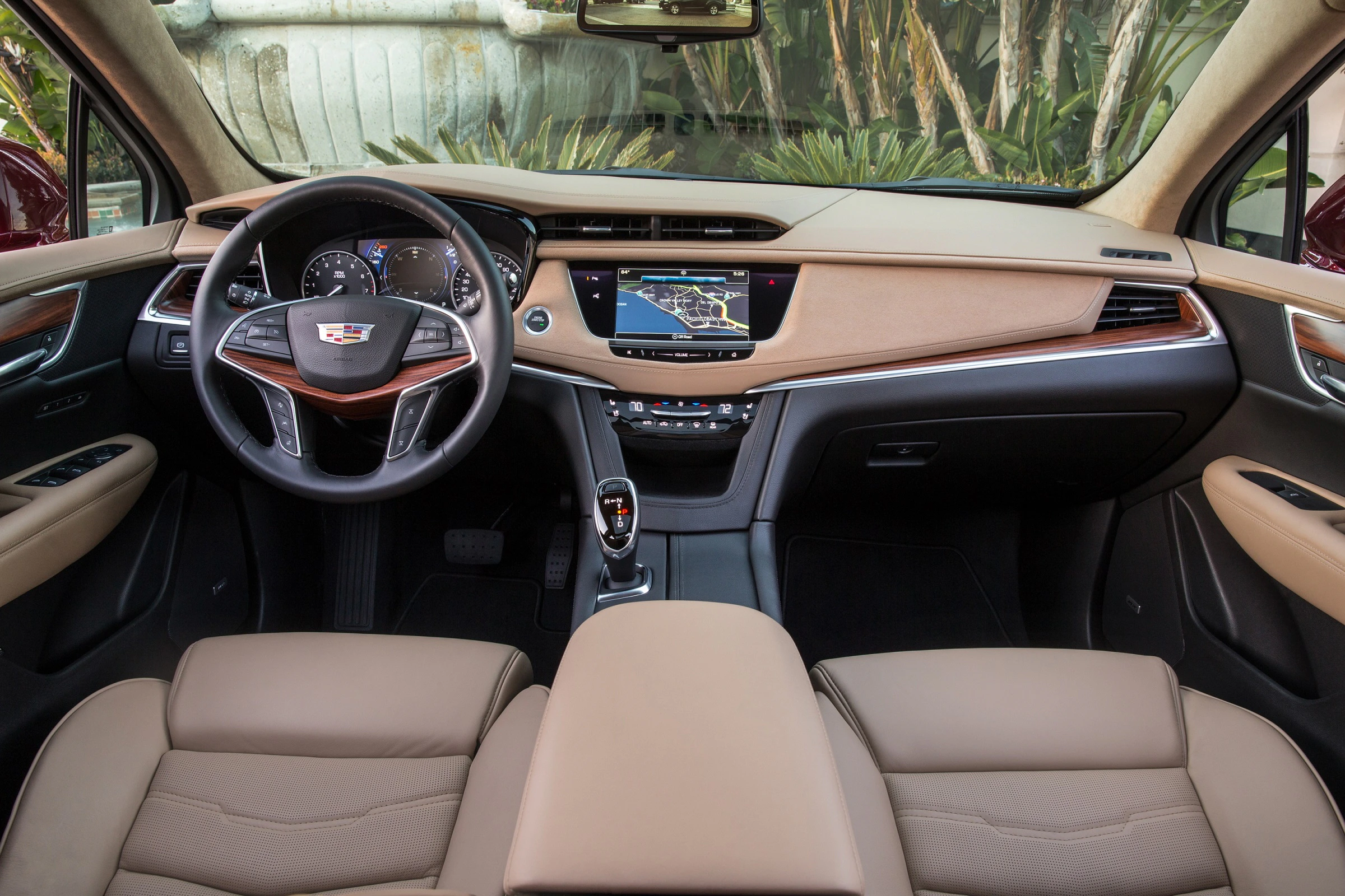 Innenraum eines Autos mit modernem Armaturenbrett, Lenkrad, Touchscreen-Navigation und beigen Ledersitzen. Elegantes, luxuriöses Design.