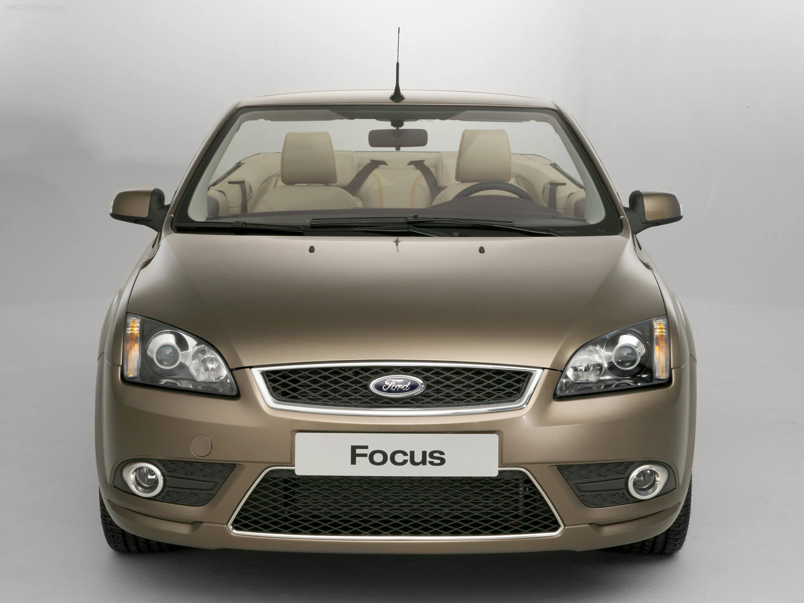 Frontansicht eines goldfarbenen Ford Focus Cabrio mit geschlossenem Dach, gut sichtbarem Ford-Logo und modernen Scheinwerfern.