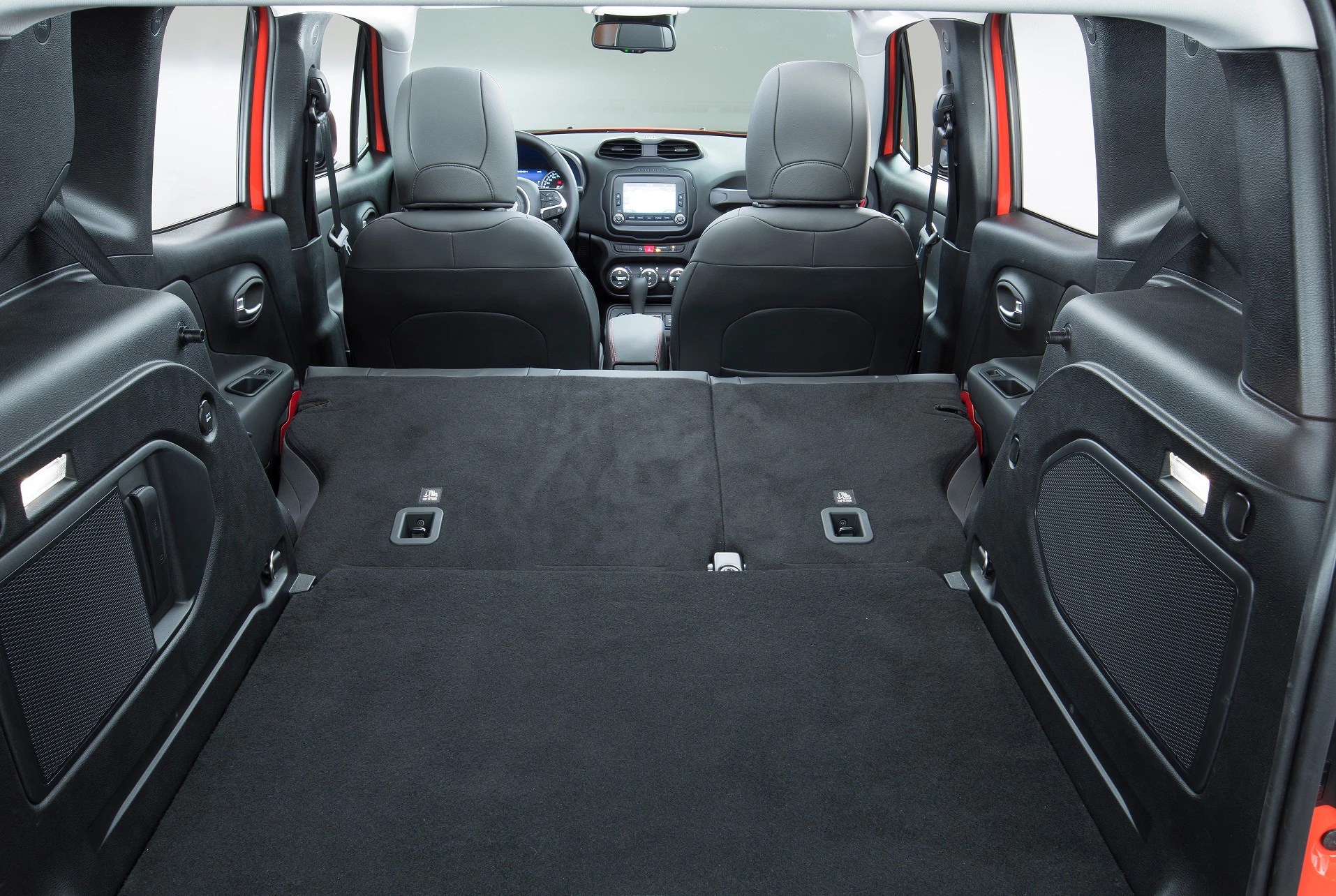 Blick auf den Kofferraum eines Autos mit umgeklappten Rücksitzen. Geräumiger Innenraum mit moderner schwarzer Ausstattung.