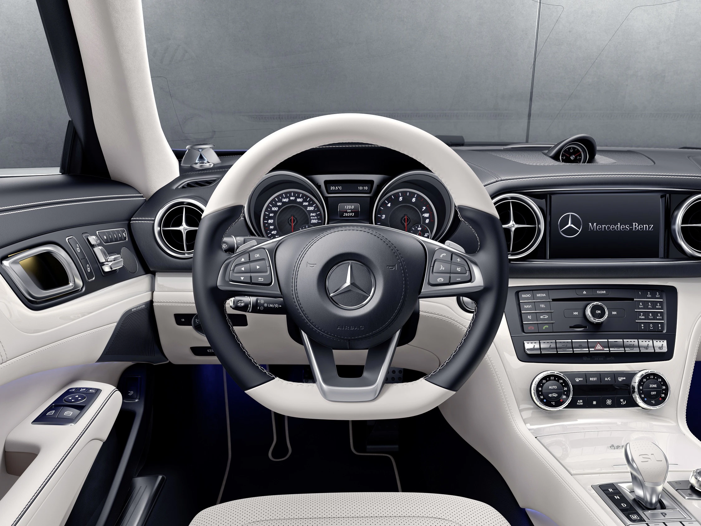 Innenraum eines Mercedes-Benz mit Lederlenkrad, digitalen Anzeigen und einem modernen Armaturenbrett in heller Farbgebung.