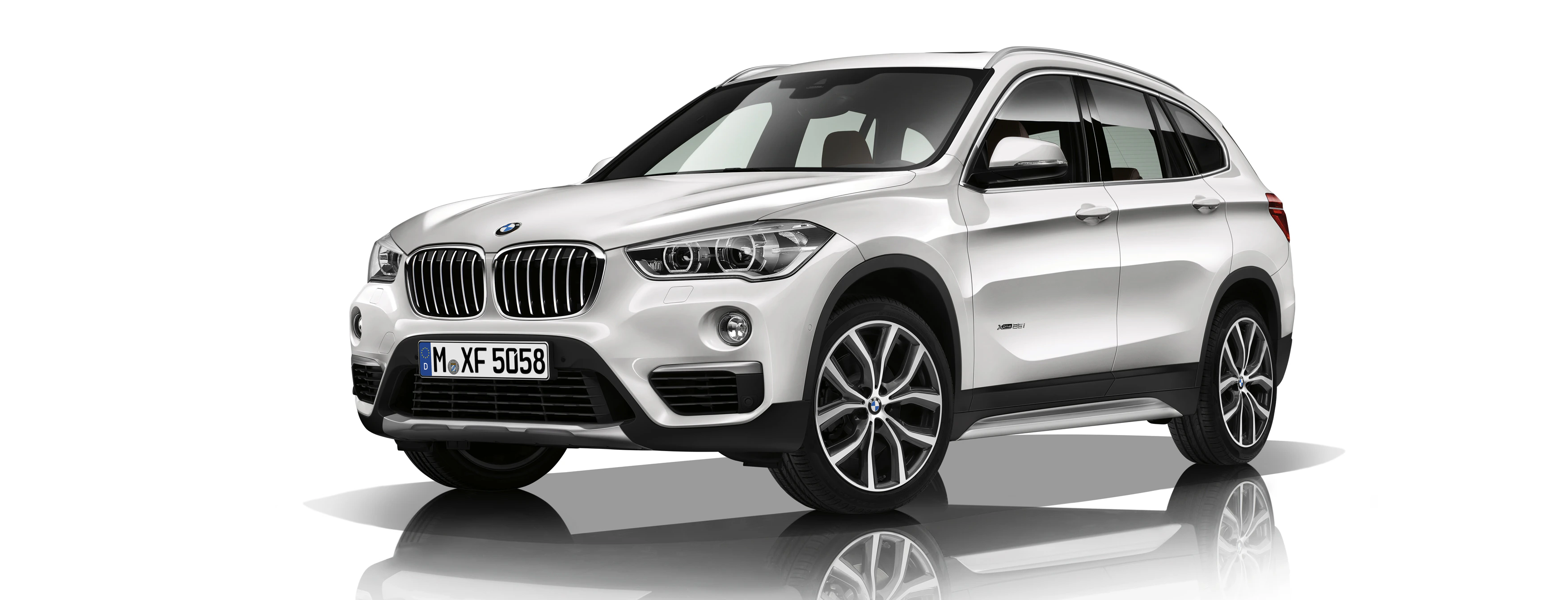 Weißer BMW SUV auf weißem Hintergrund, von schräg vorne aufgenommen. Fahrzeugkennzeichen sichtbar.