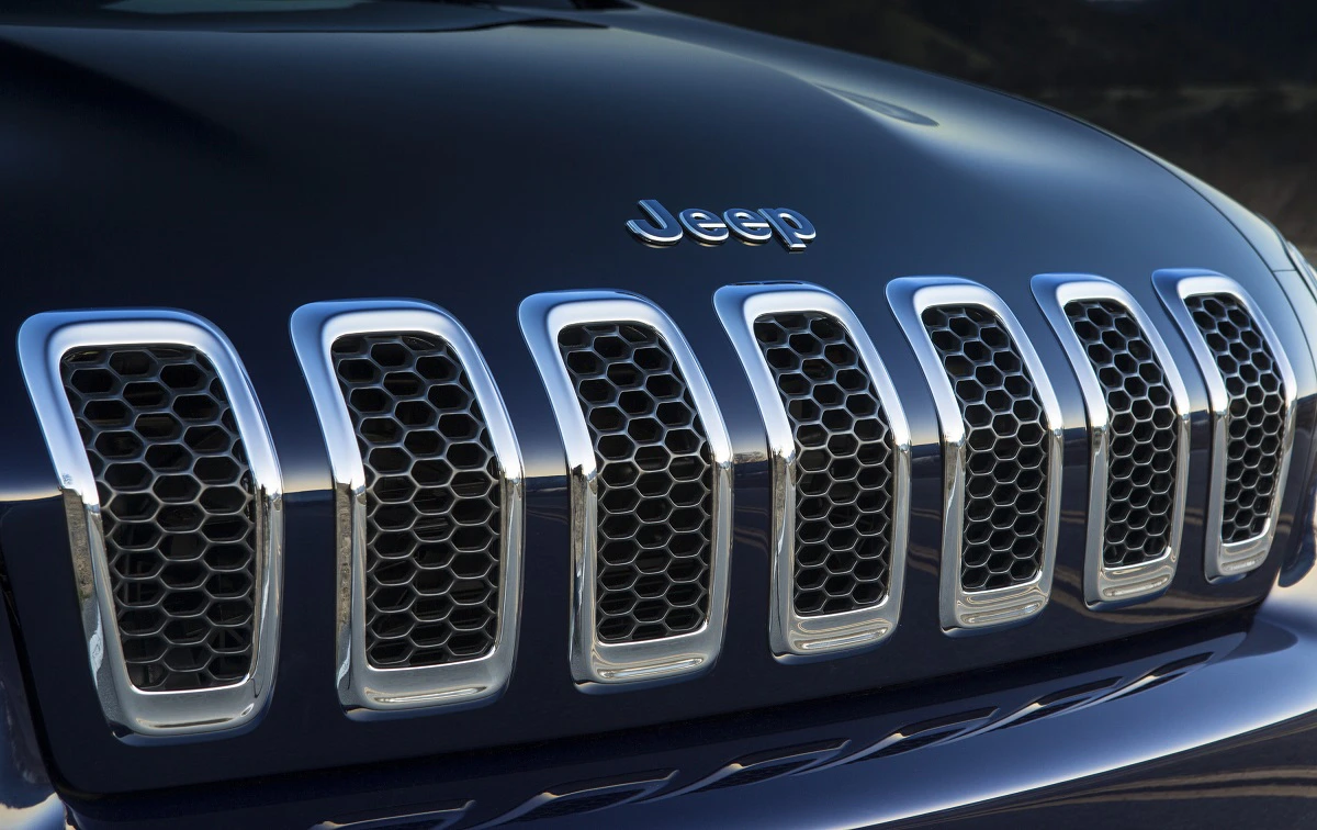 Nahaufnahme des Kühlergrills eines schwarzen Jeeps mit silbernen Umrandungen und markantem Wabendesign.