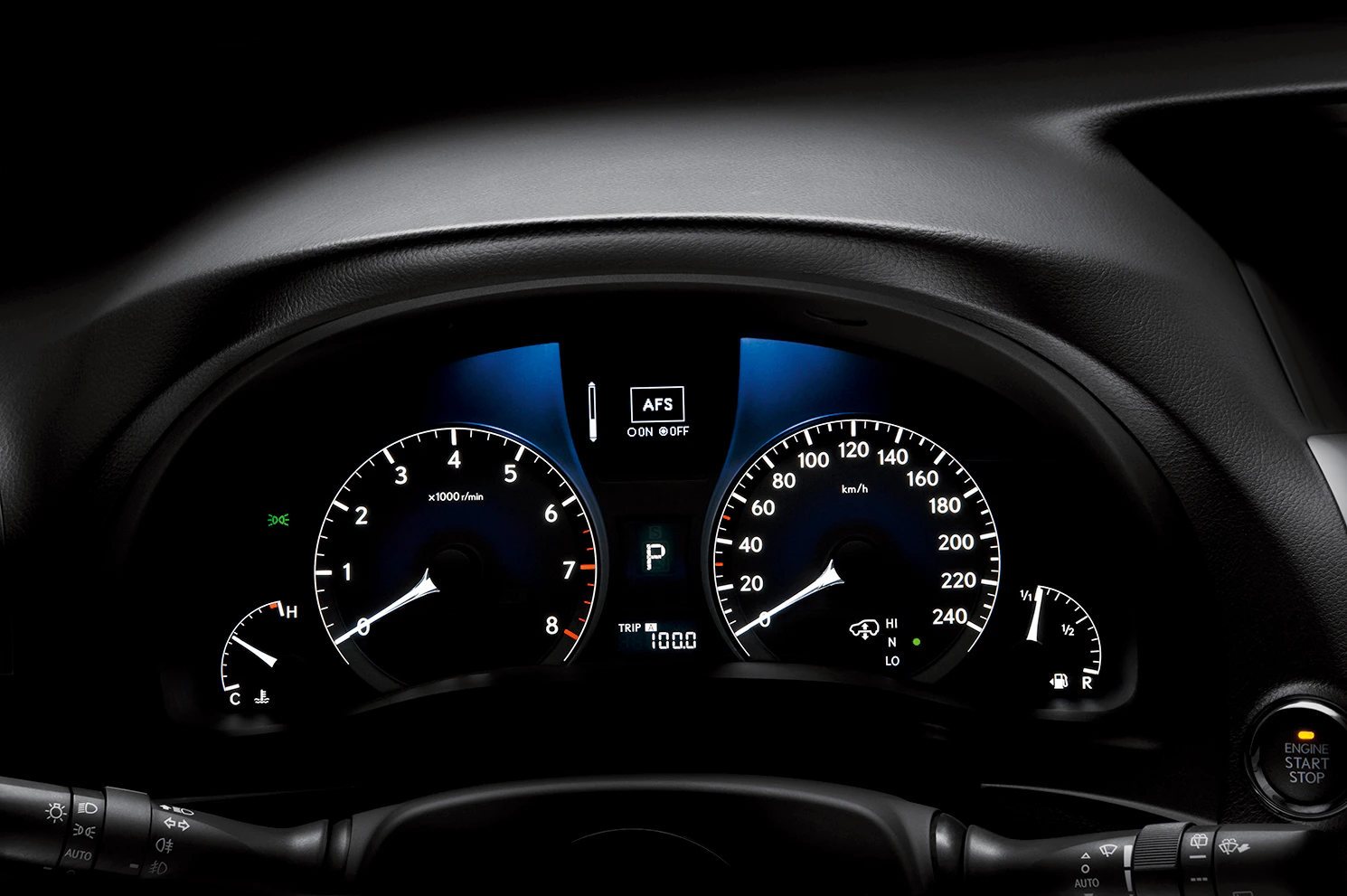 Armaturenbrett eines Autos bei Nacht, zeigt Tachometer, Drehzahlmesser, Tankanzeige und weitere Anzeigen, Hebel im Vordergrund.