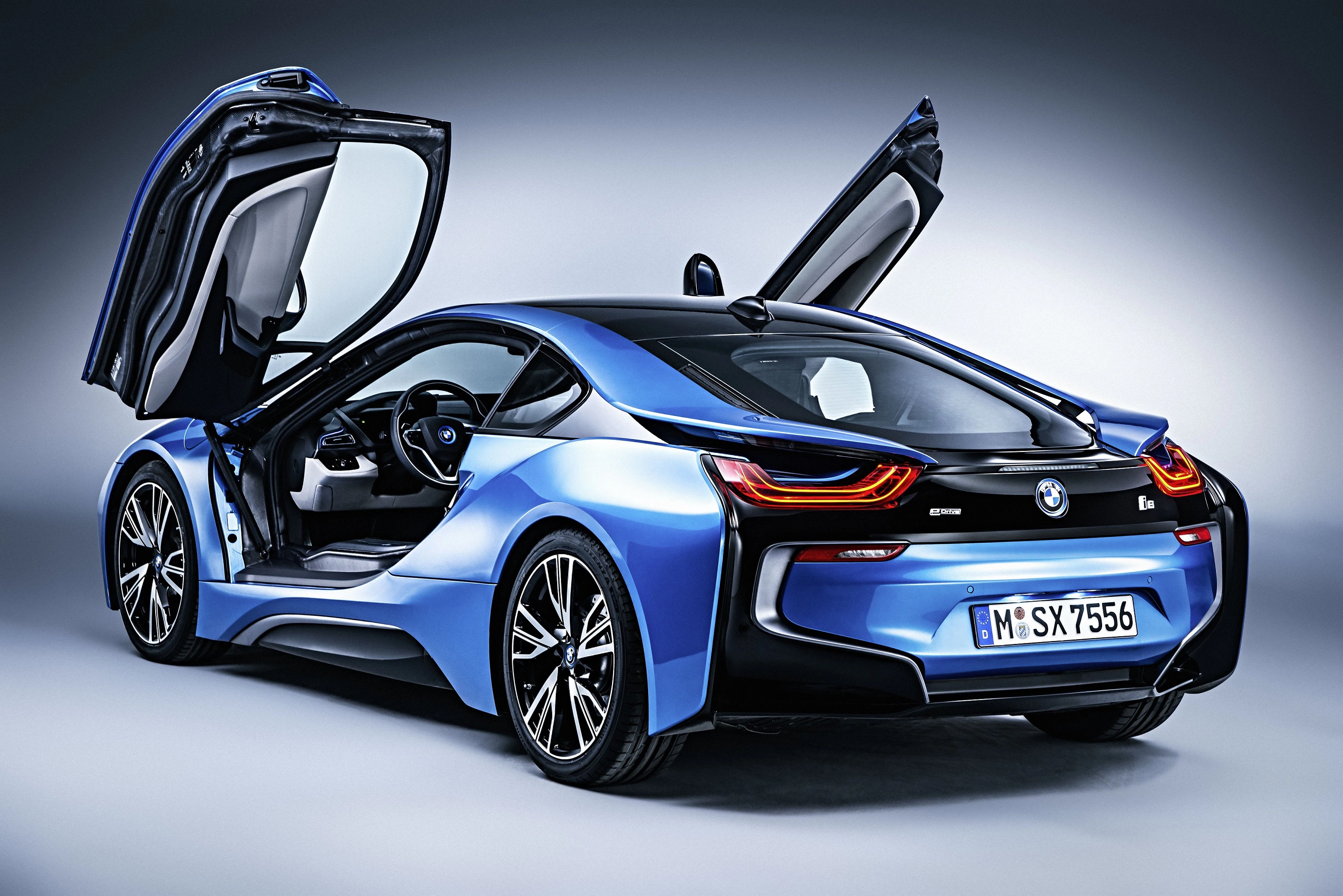 Blauer Sportwagen mit geöffneten Flügeltüren, seitliche Rückansicht, modernes Design und futuristische Linien.