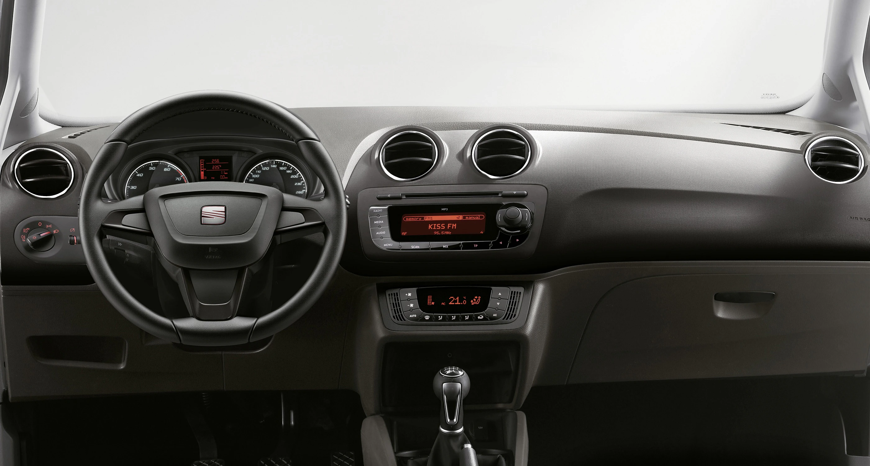 Innenraum eines Autos mit Lenkrad, Armaturenbrett und einer Mittelkonsole mit Radio- und Klimasteuerung.