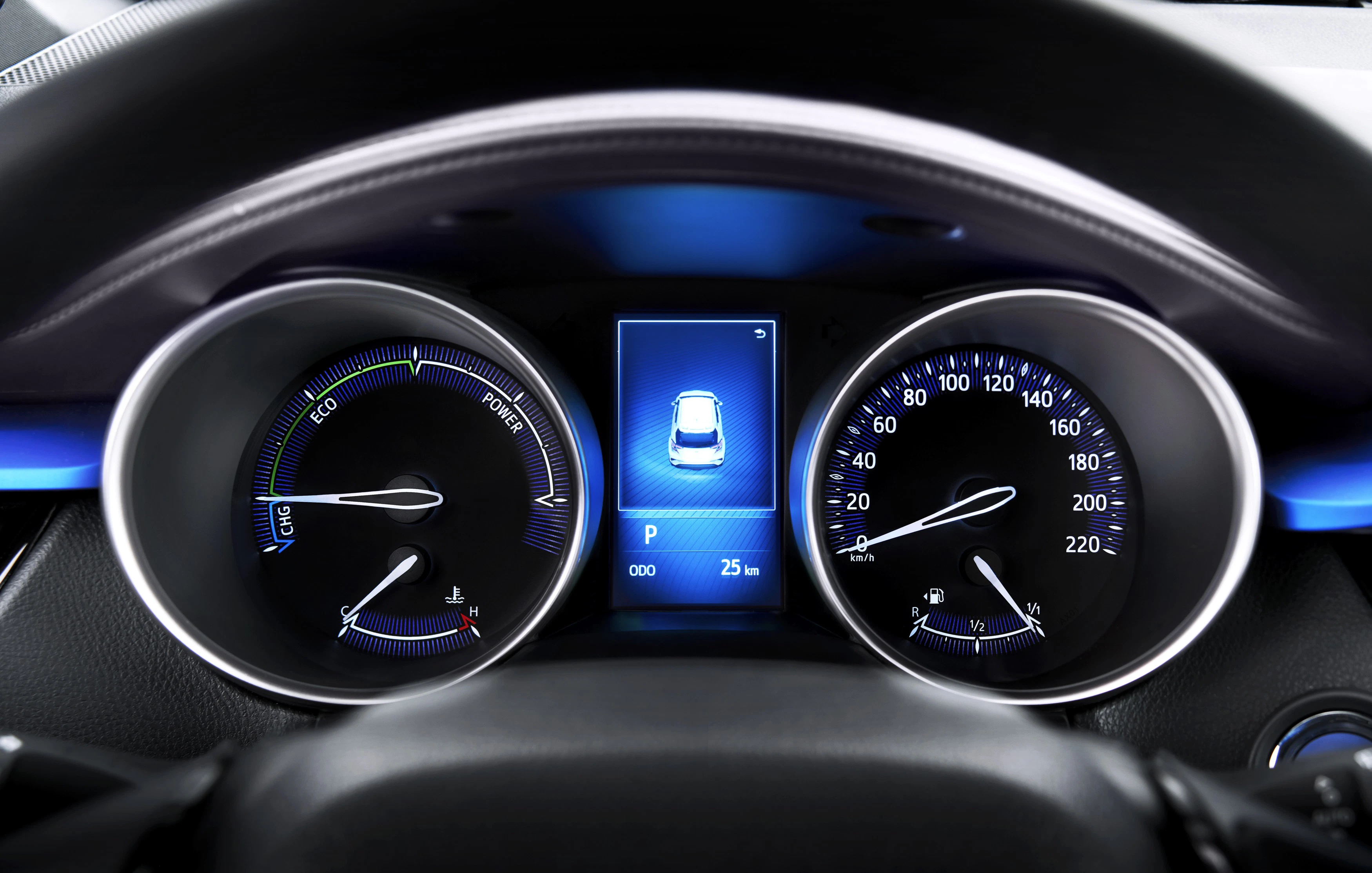 Nahaufnahme eines Auto-Cockpits mit Tacho- und Drehzahlanzeige sowie digitalem Display mit Fahrzeugsymbol; Geschwindigkeit bei 0 km/h.