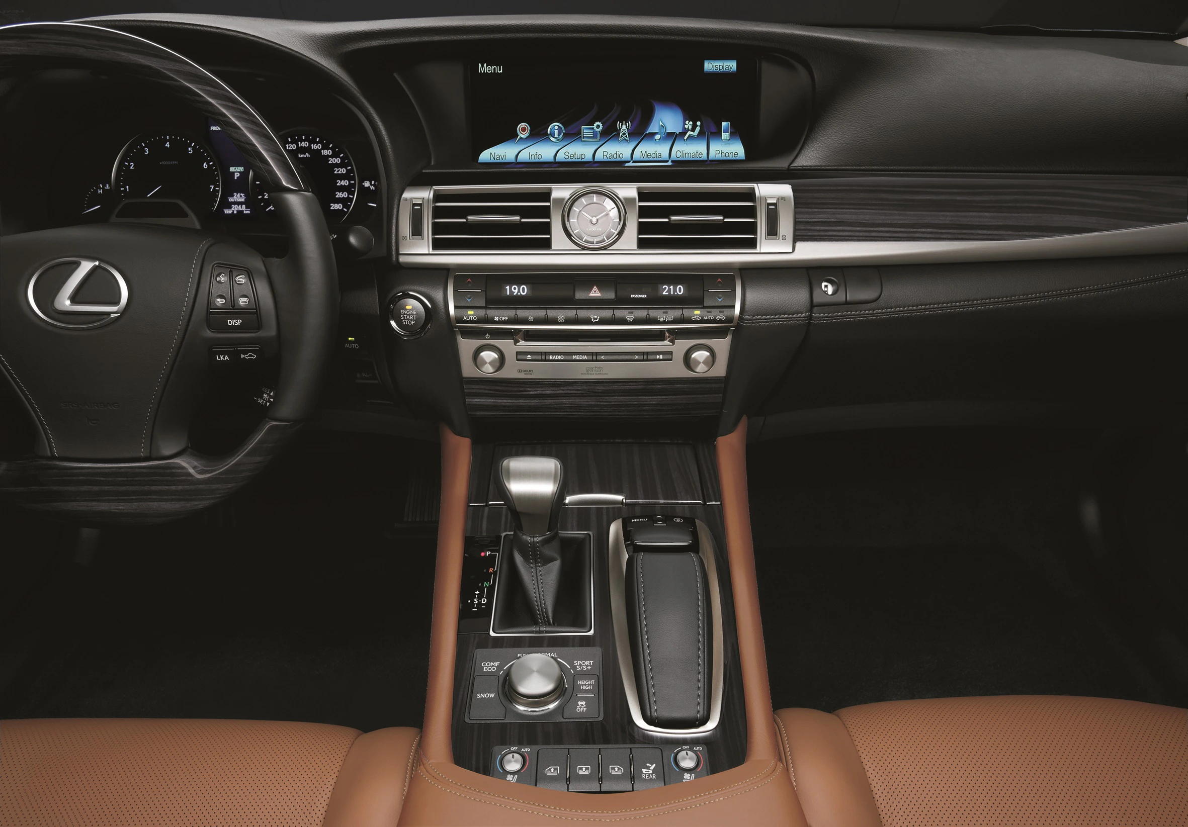 Innenraum eines Autos mit braunen Ledersitzen, einem modernen Lenkrad, einem Infotainment-Bildschirm und einem zentralen Bedienfeld.