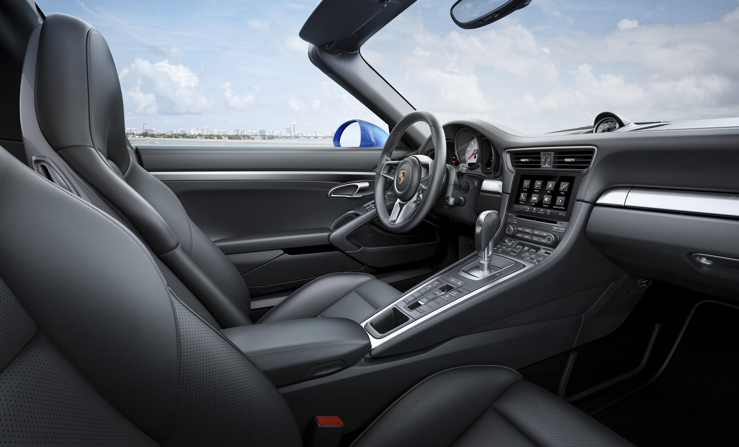 Innenraum eines luxuriösen Sportwagens mit schwarzen Ledersitzen, modernem Armaturenbrett und einer klaren Aussicht durch die Windschutzscheibe.