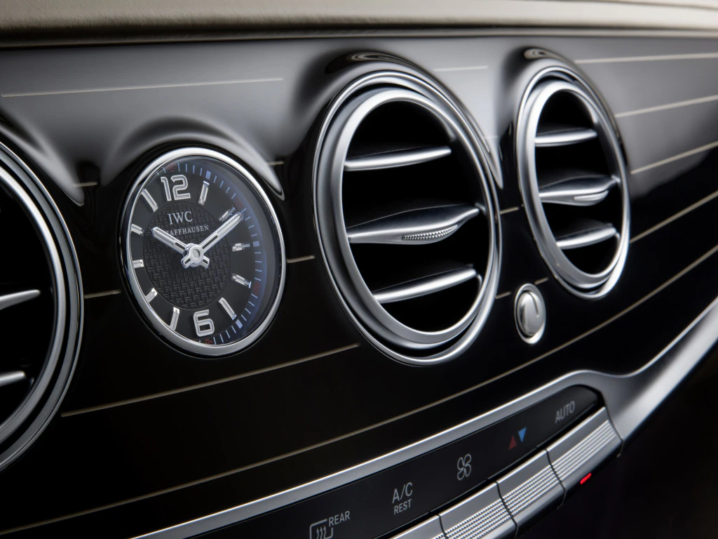 Nahaufnahme eines Mercedes-Armaturenbretts mit IWC-Uhr, Lüftungsdüsen und Bedienelementen für Klimaeinstellungen.