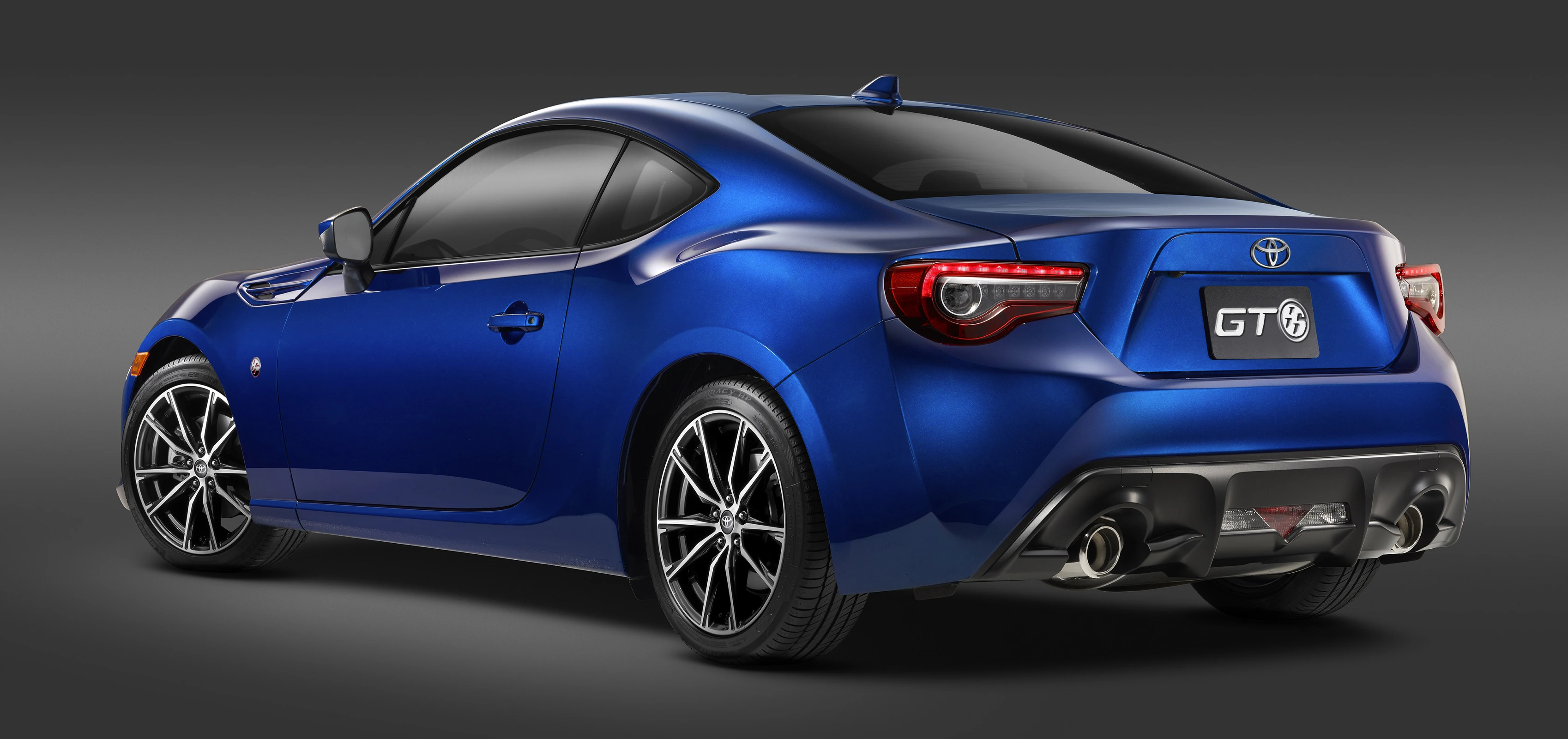 Blaues Sportcoupé von schräg hinten, mit Doppelauspuff, markanten Rückleuchten und der Aufschrift "GT 86" auf dem Kennzeichen.