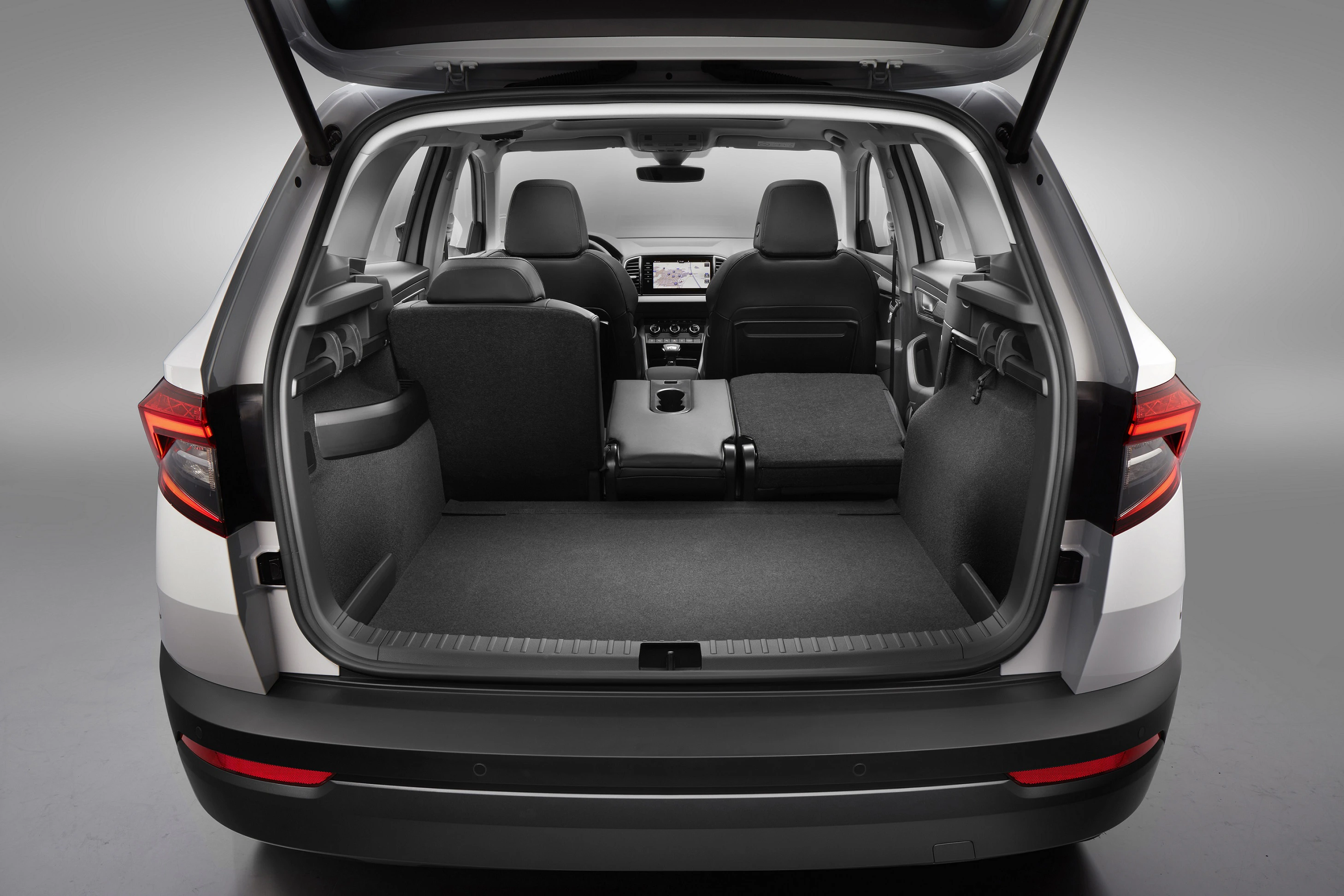 Offener Kofferraum eines Autos mit umgeklappten Rücksitzen, was einen geräumigen Laderaum zeigt. Die Innenausstattung ist modern und funktionell.