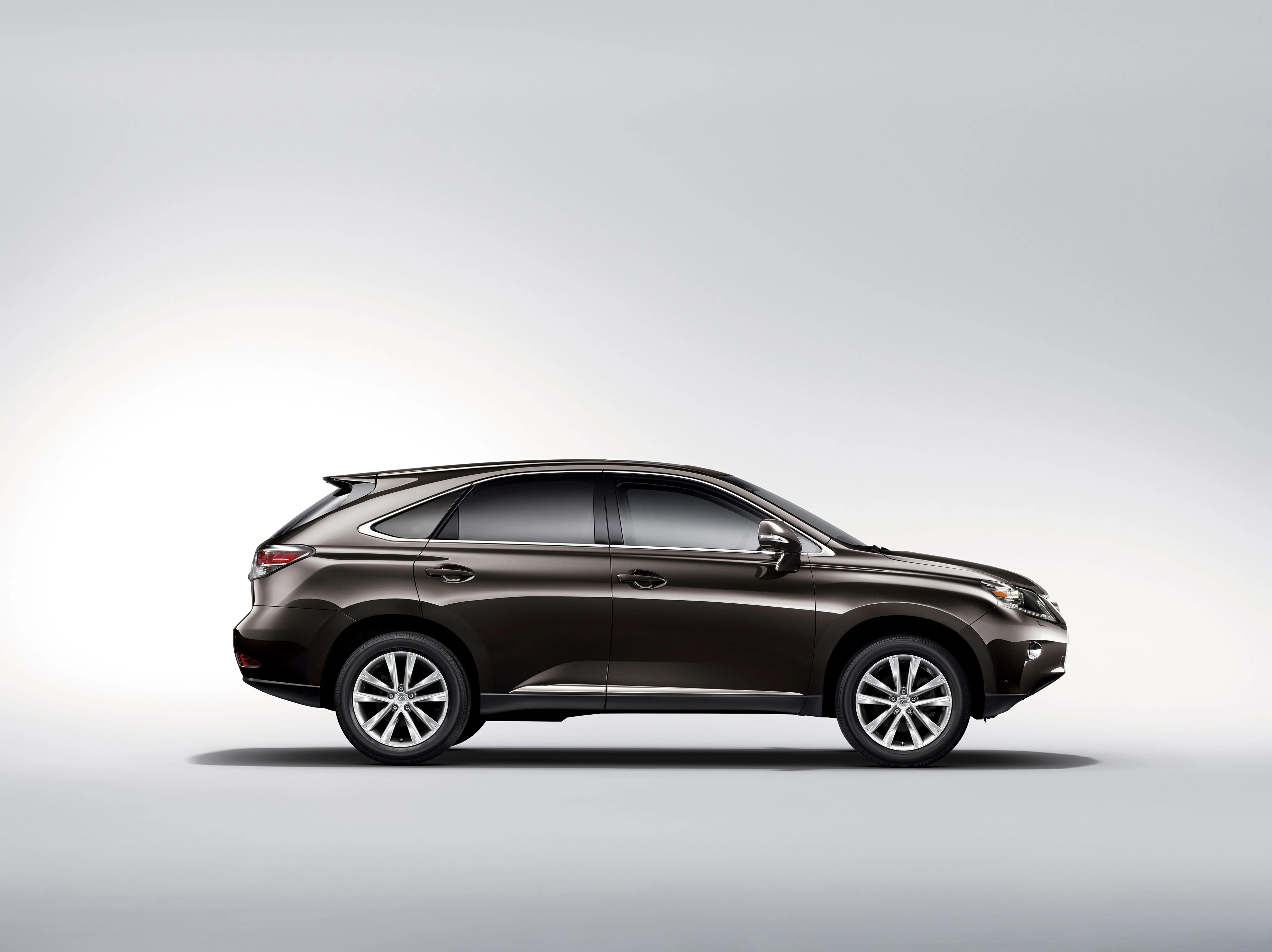 Seitenansicht eines dunkelbraunen SUVs vor einem hellgrauen Hintergrund. Der Wagen hat große Felgen und eine aerodynamische Form.