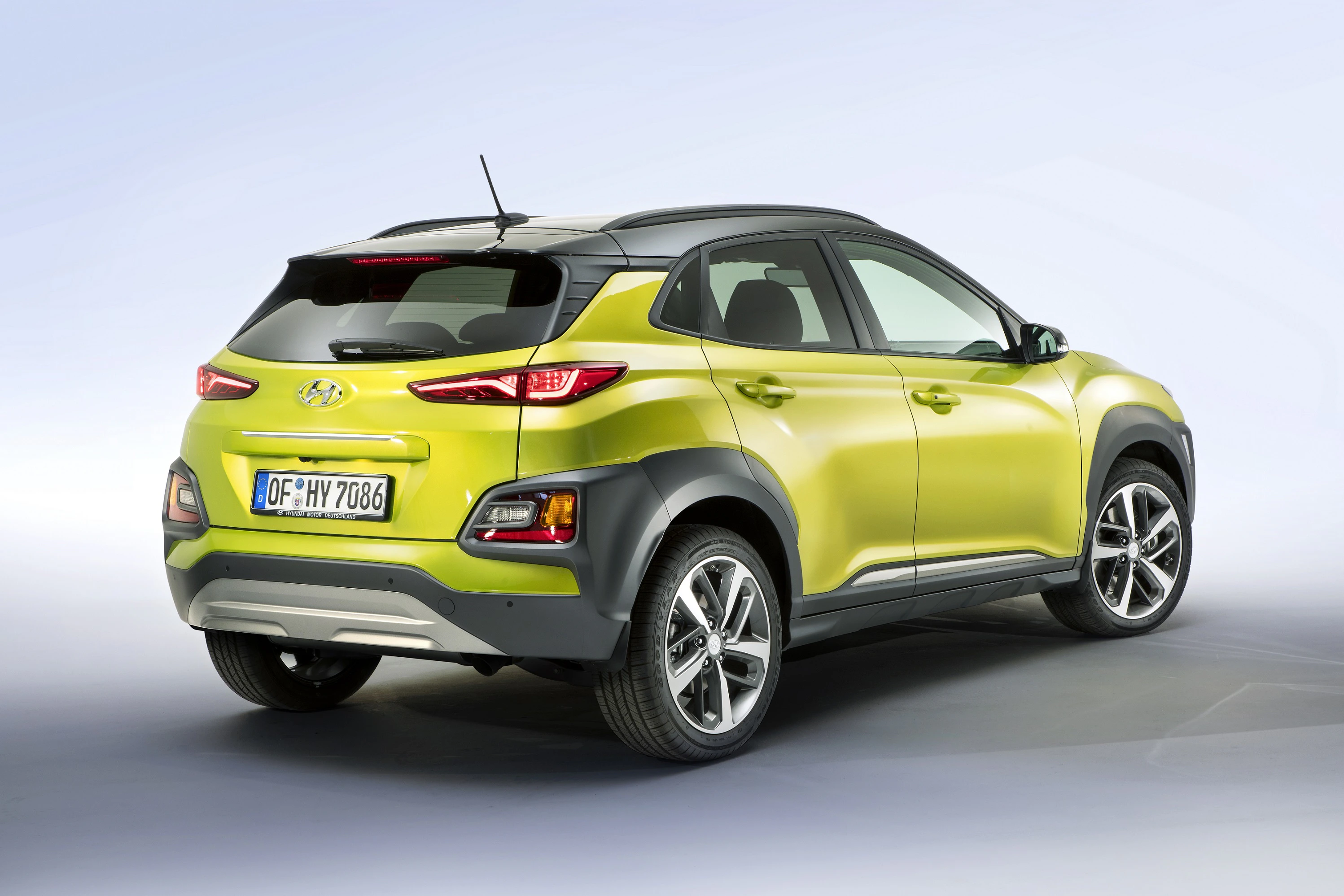 Grünes Auto von hinten, Hyundai-Modell mit deutschen Kennzeichen, moderner SUV-Stil, stehende Position auf hellem Hintergrund.