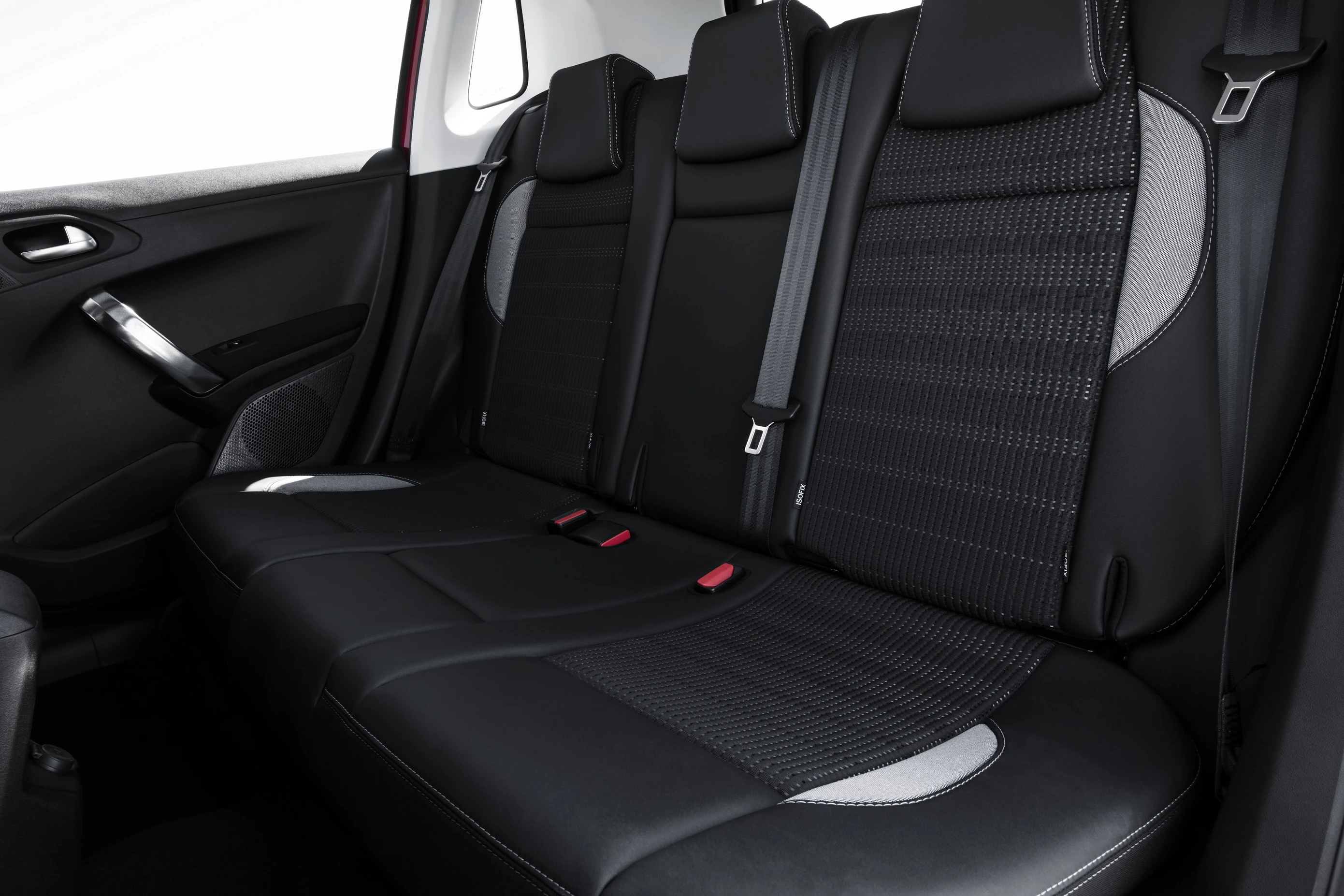 Rücksitzbank eines Autos mit schwarzem Lederbezug, roten Akzenten und Sicherheitsgurten. Moderne Innenausstattung.