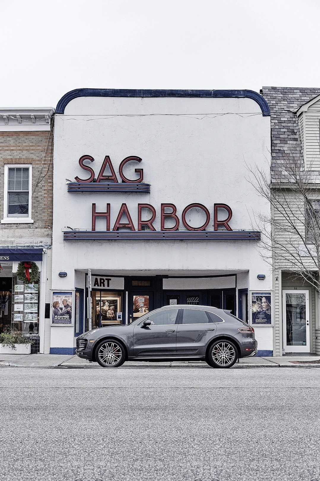 Graues Auto steht vor dem Sag Harbor-Gebäude in einer kleinen Stadt mit nostalgischem Charme und roten Leuchtschriftzügen.