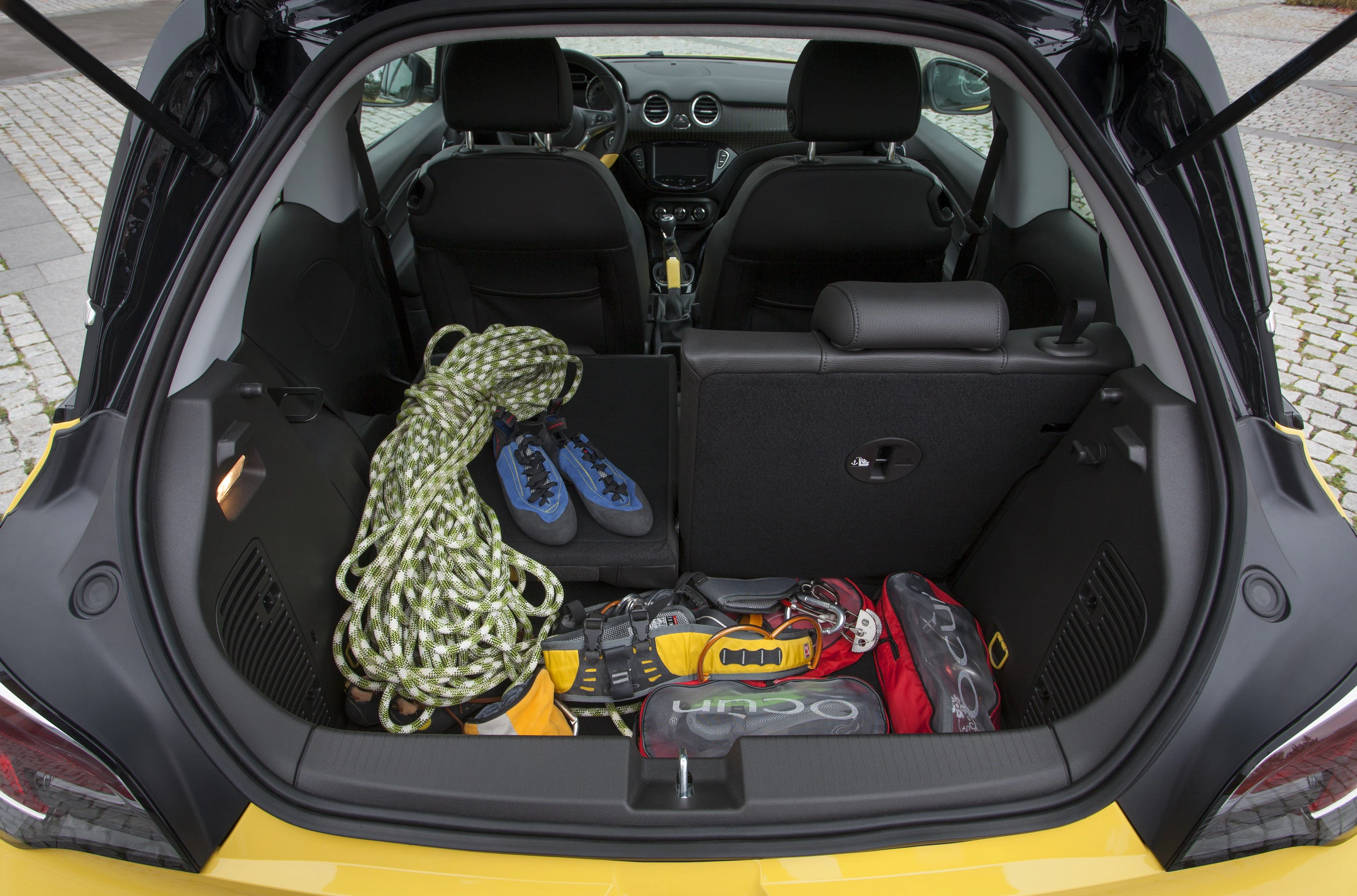 Kofferraum eines Autos mit Kletterausrüstung: Seil, Schuhe, Helm und Tasche. Die Rücksitze sind umgeklappt.