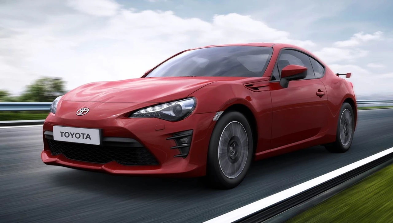 Roter Sportwagen auf einer Straße, dynamische Perspektive, Toyota-Logo sichtbar.