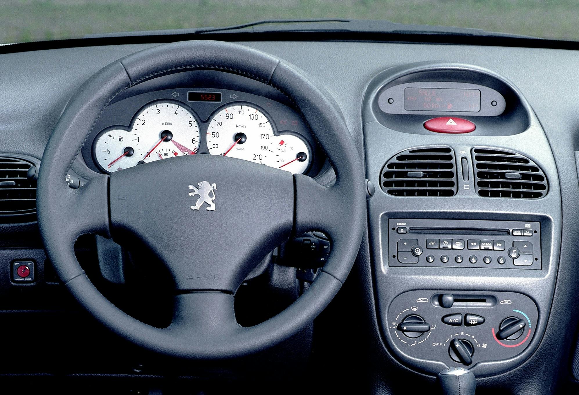 Innenraum eines Autos mit Lenkrad, Armaturenbrett, Klimareglern und Autoradio. Sicht auf Tachometer und Bedienelemente.