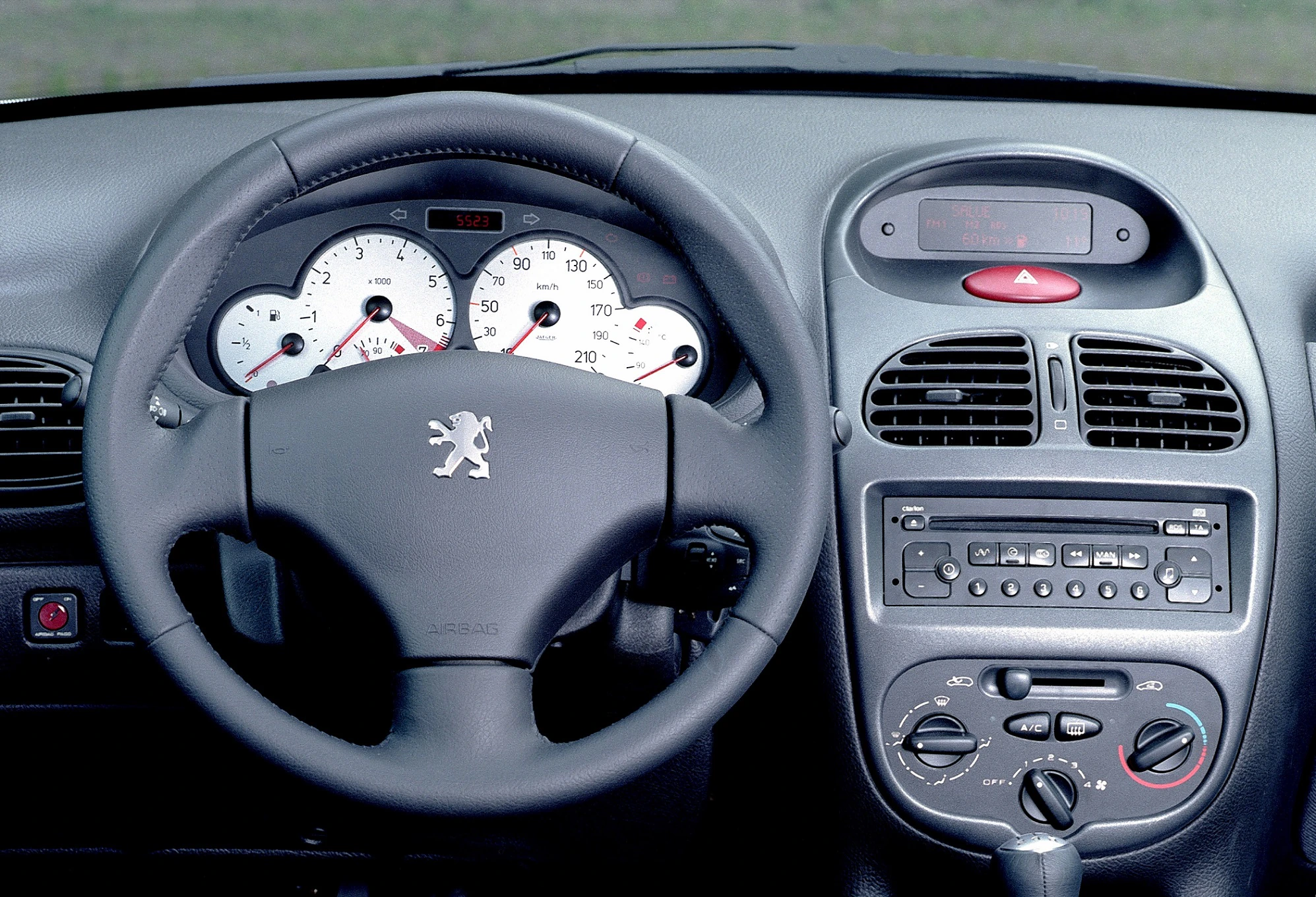 Innenraum eines Autos mit Lenkrad, Armaturenbrett, Klimareglern und Autoradio. Sicht auf Tachometer und Bedienelemente.