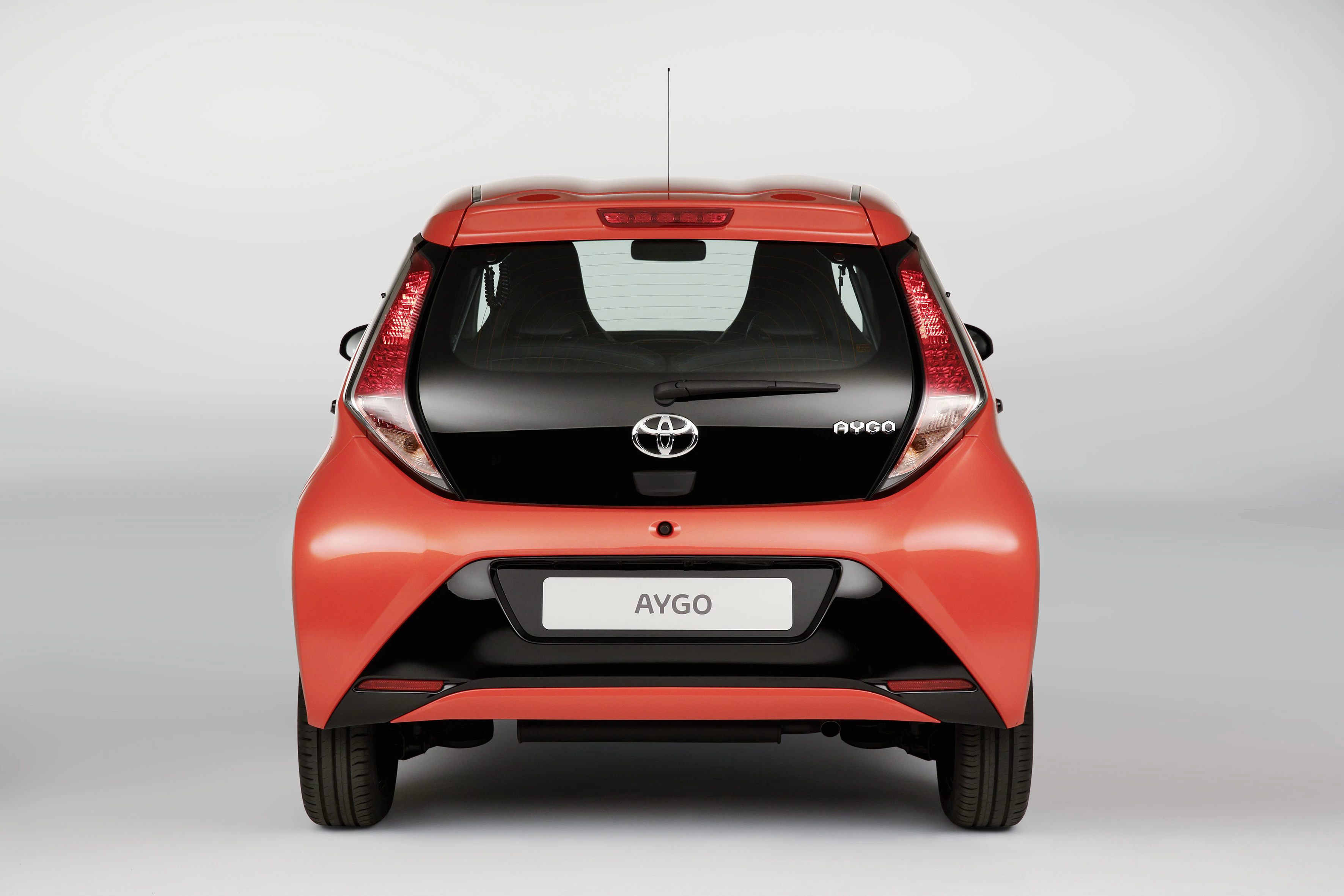 Roter Toyota Aygo von hinten, mit markanten Rückleuchten und einem schwarzen Stoßfänger.