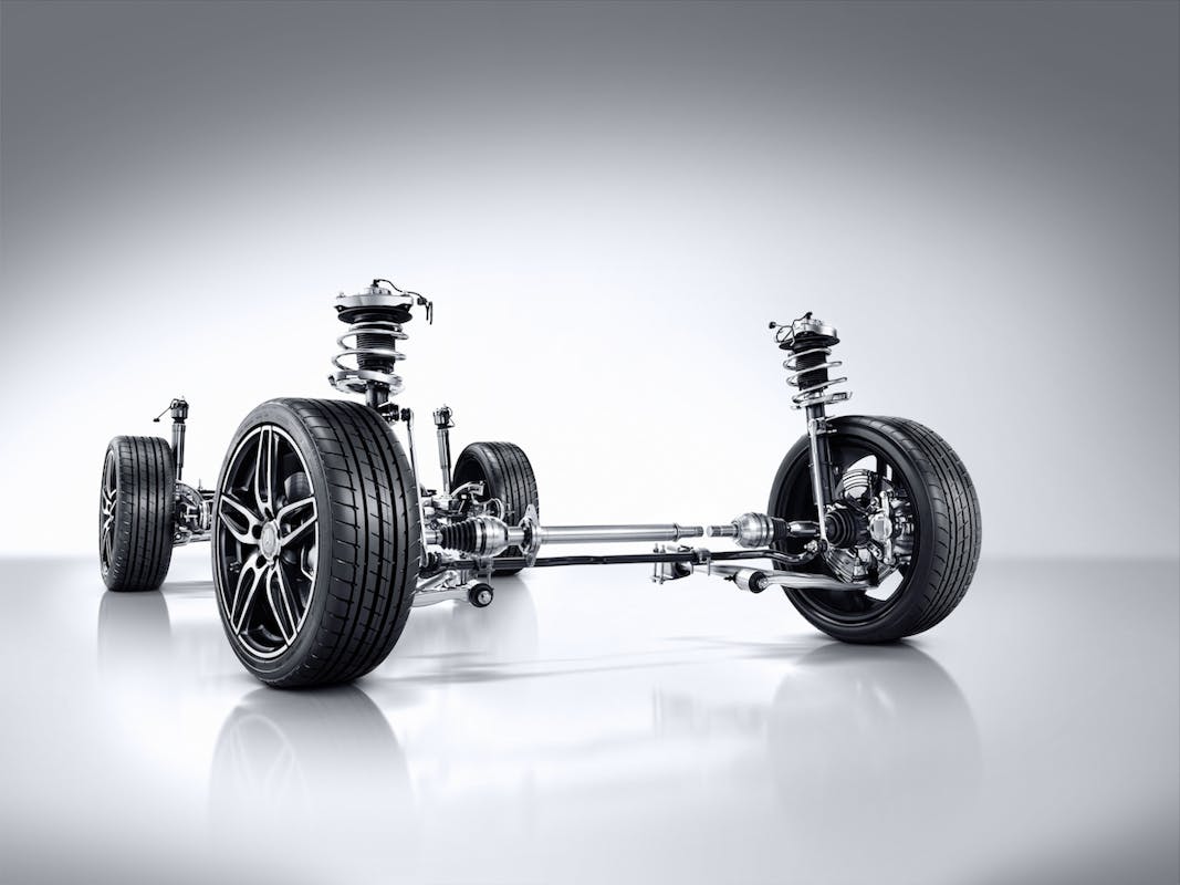 Autofahrwerk mit Reifen und Federungssystem, dargestellt auf einem hellen Hintergrund. Hochwertige Details sichtbar.