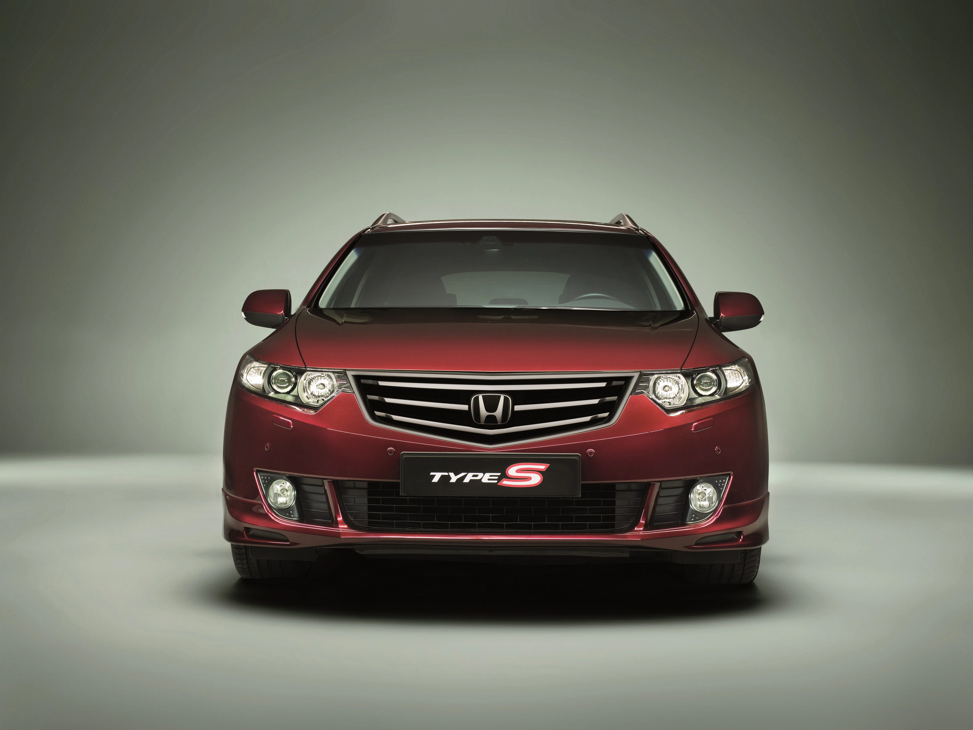 Rote Limousine der Marke Honda, Modell Type S, frontal auf neutralem Hintergrund fotografiert.
