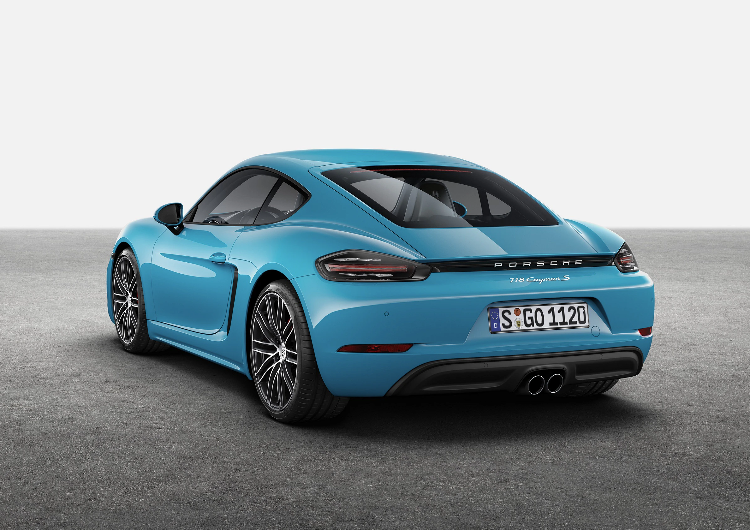 Ein blauer Sportwagen, Porsche 718 Cayman S, steht auf grauem Asphalt. Sicht auf die Rückseite, Kennzeichen sichtbar.