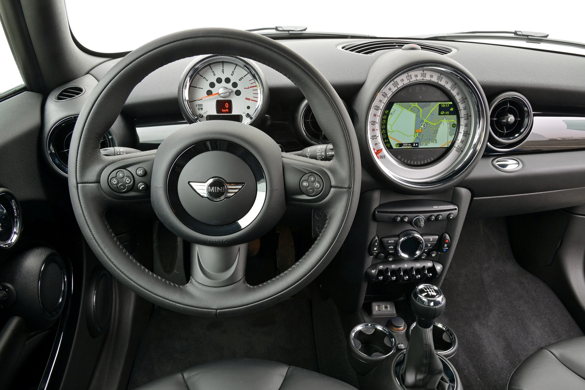 Innenraum eines Autos mit Lenkrad, Tacho und großem Navigationsdisplay. Das Design wirkt modern und sportlich.