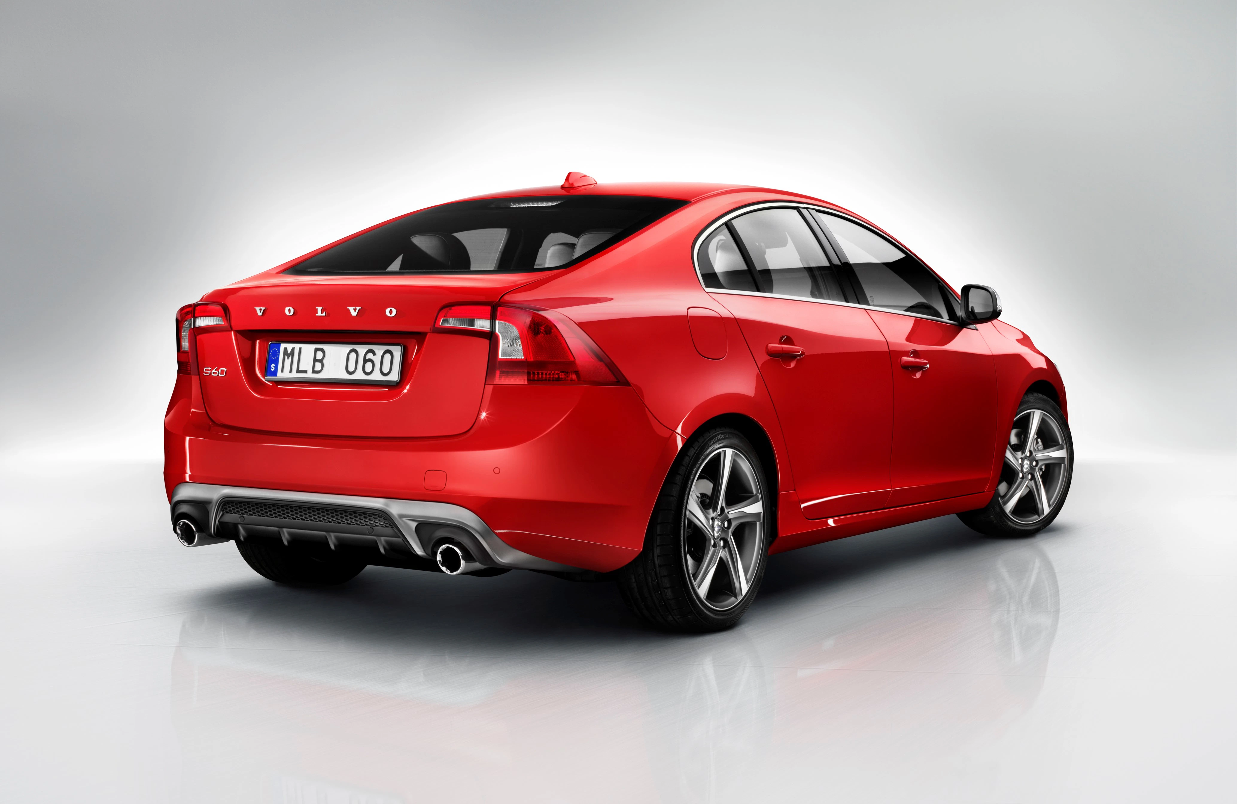 Roter Volvo S60 mit sportlichem Design, von hinten und seitlich fotografiert, auf neutralem Hintergrund.