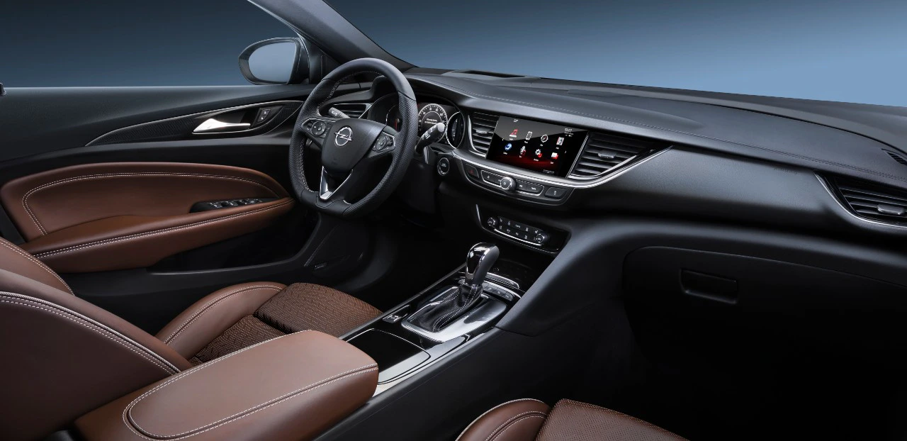 Innenraum eines modernen Autos mit braunen Ledersitzen, Multifunktionslenkrad und Touchscreen-Display. Luxuriös und elegant gestaltet.