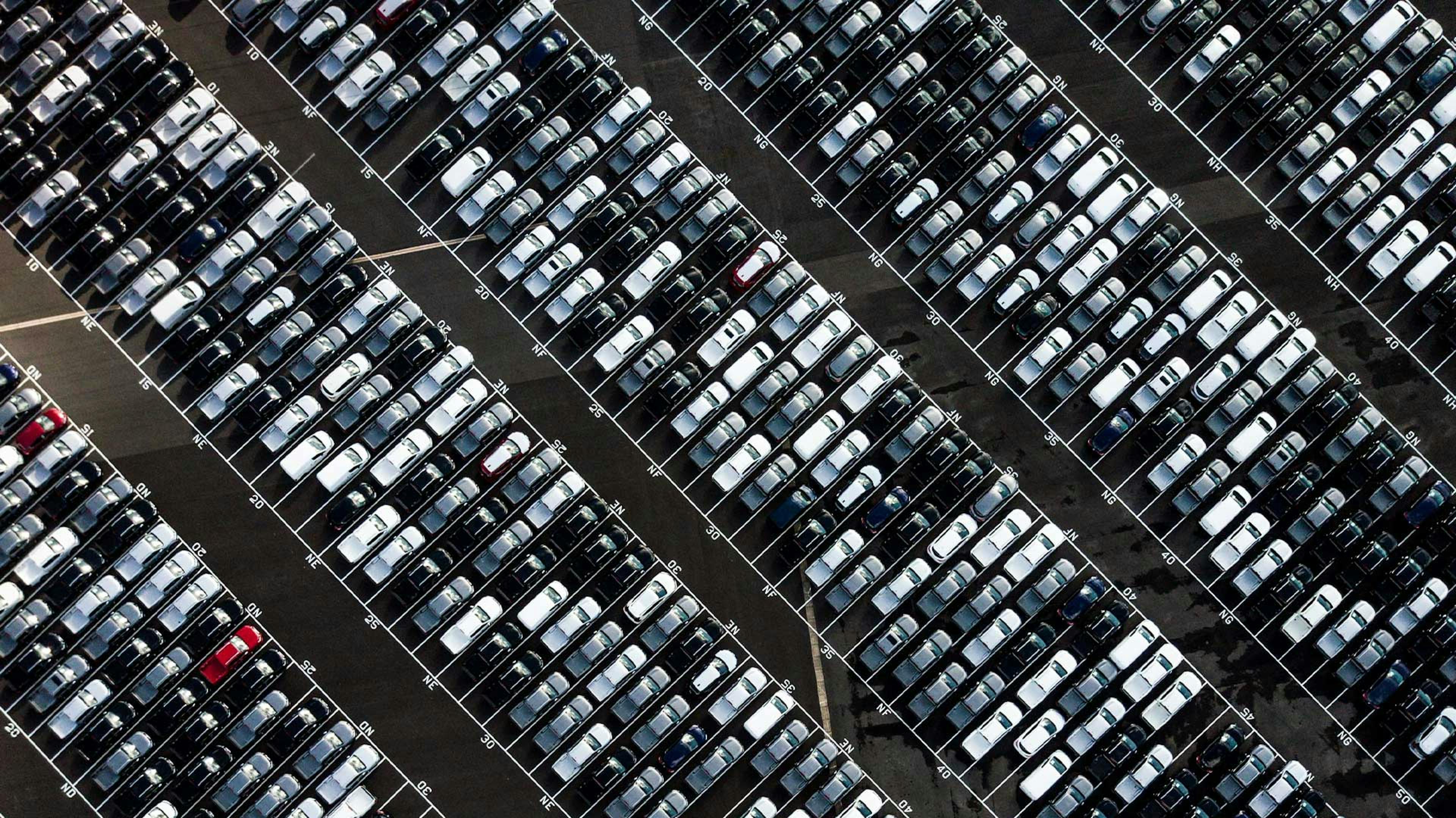 Luftaufnahme eines Parkplatzes, der voller Pkw in unterschiedlichen Farben steht.
