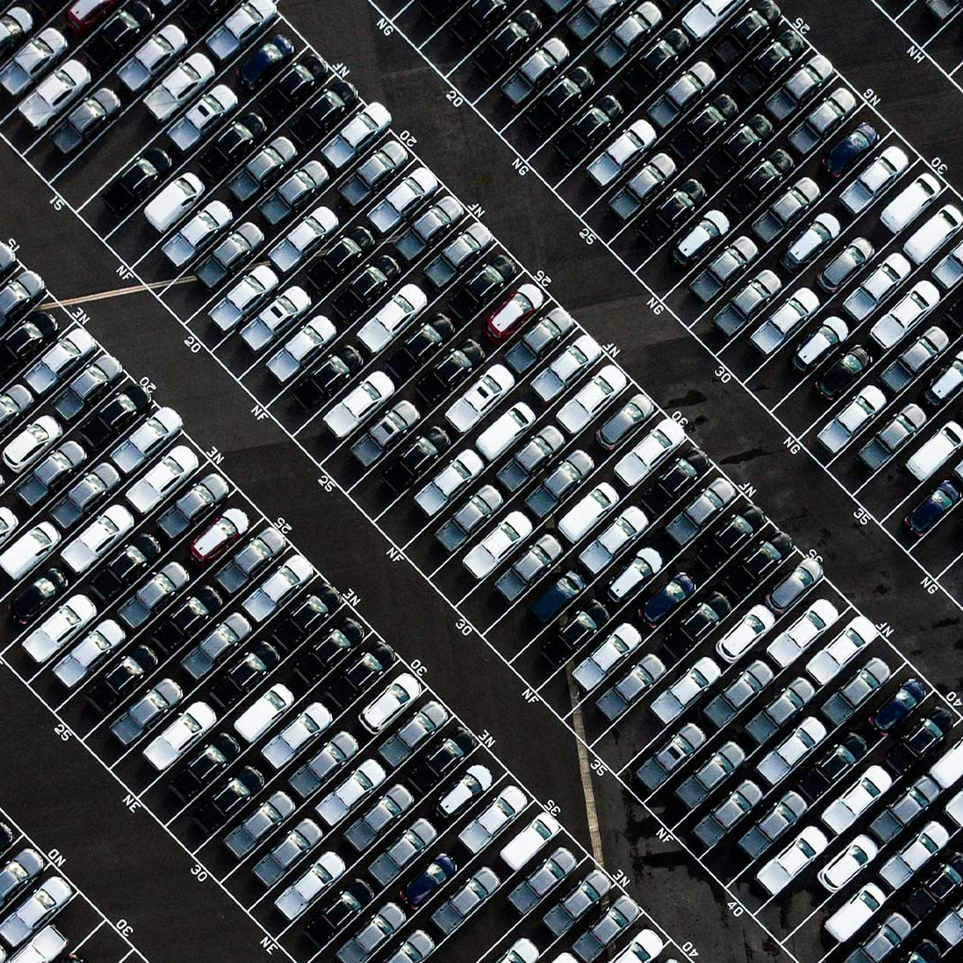 Luftaufnahme eines Parkplatzes, der voller Pkw in unterschiedlichen Farben steht.