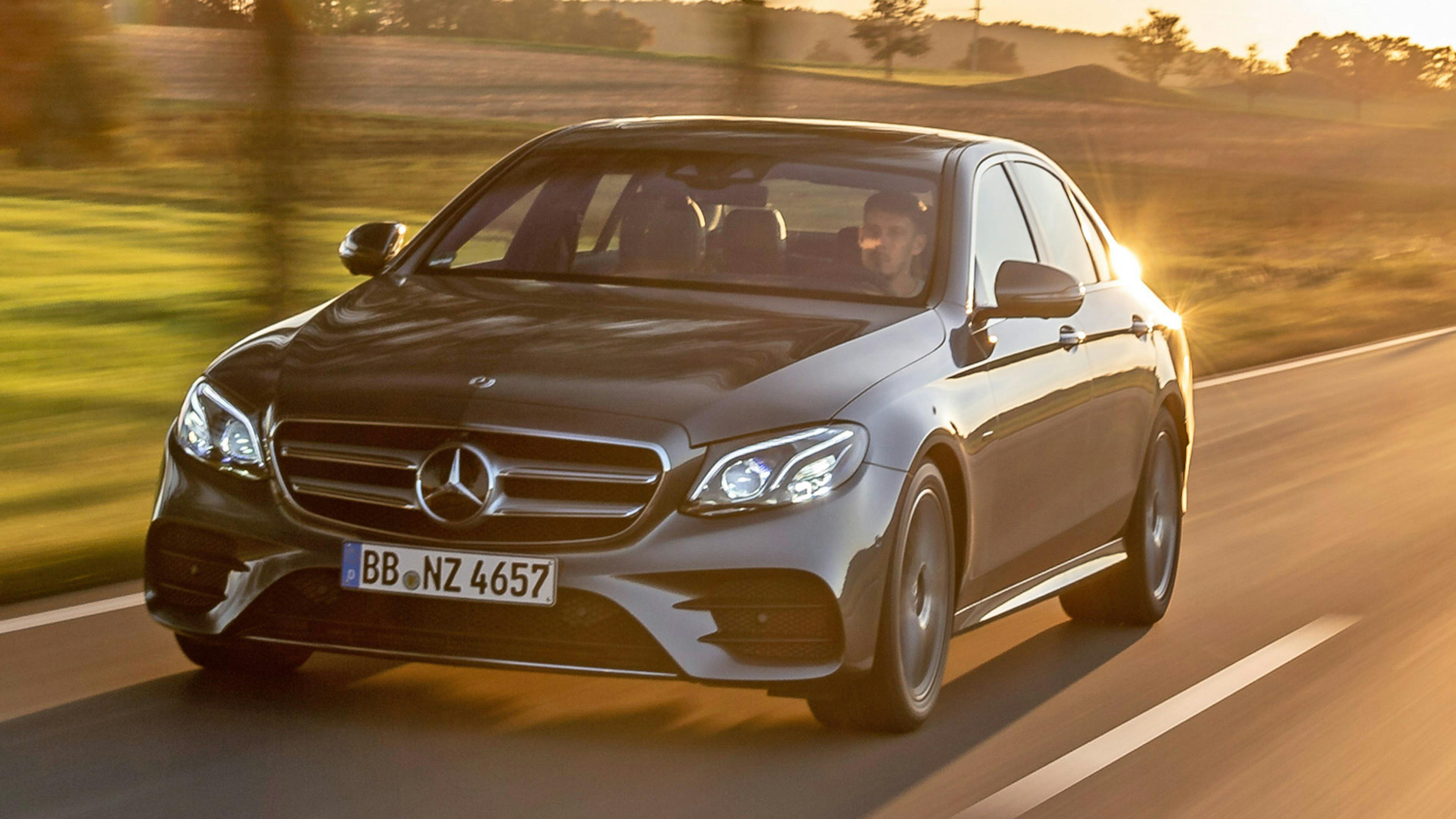 Ein silberner Mercedes-Benz E 300 de Diesel-Hybrid fährt eine Landstraße entlang