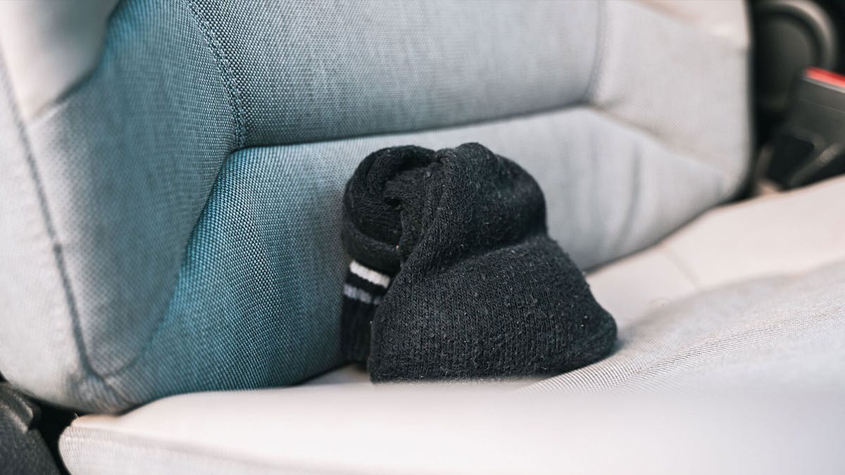 Eine mit Katzenstreu befüllte Socke liegt auf dem Beifahrersitz eines Pkw.