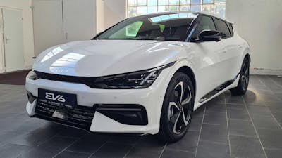 Ein weißer Kia EV6 Long Range steht in einem leeren Raum mit grauem Boden.