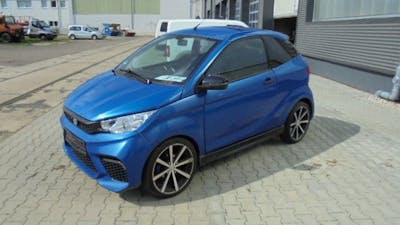 Ein blaues Aixam Emotion City Microcar steht auf einem Parkplatz.