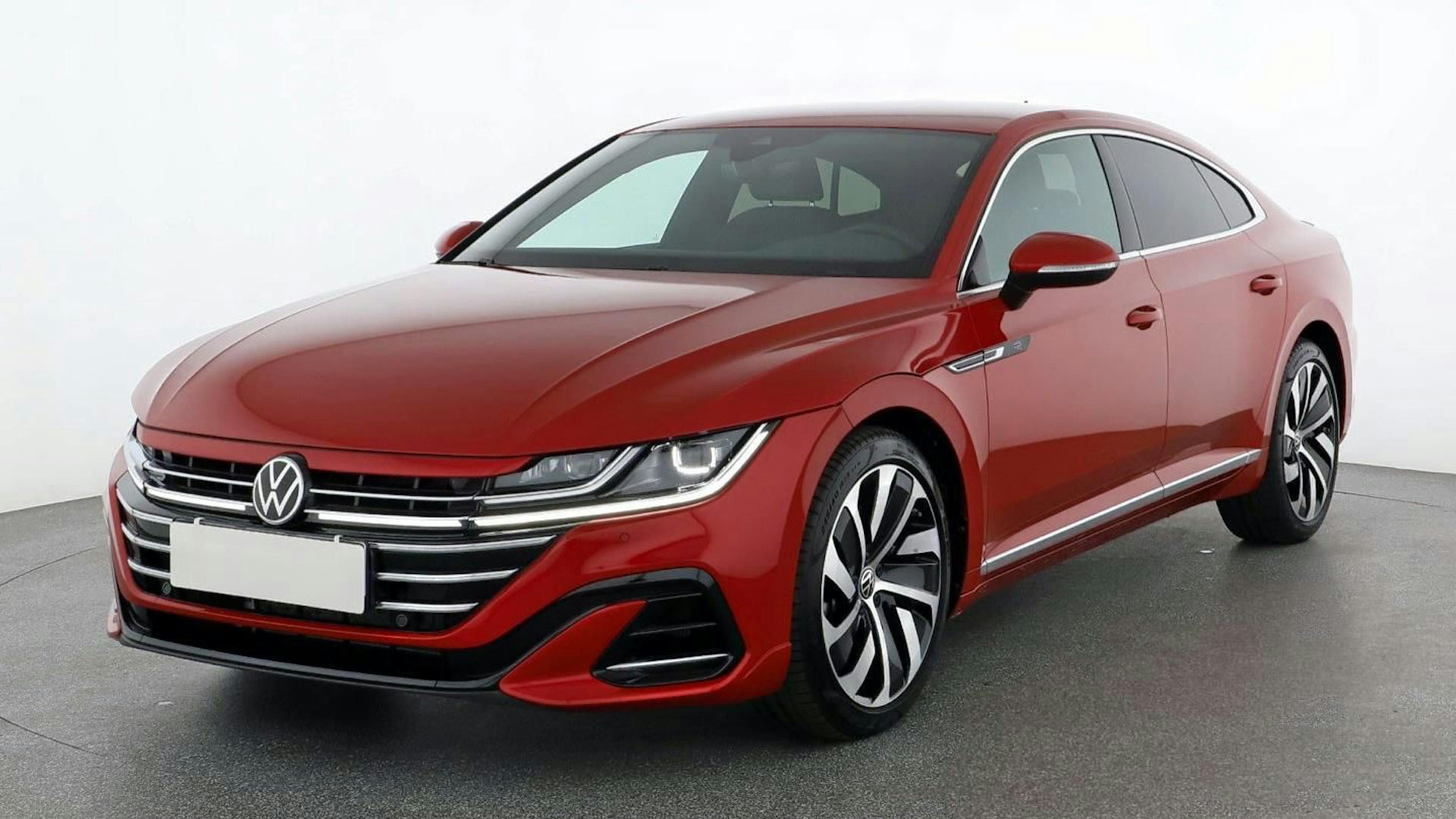 Ein roter VW Arteon steht vor einer weißen Wand.