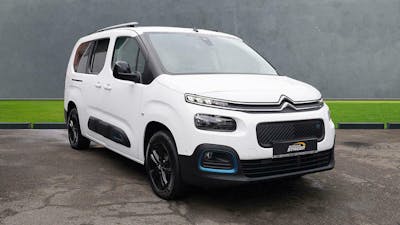 Ein weißer Citroën E-Berlingo Elektrotransporter steht vor einer grauen Wand
