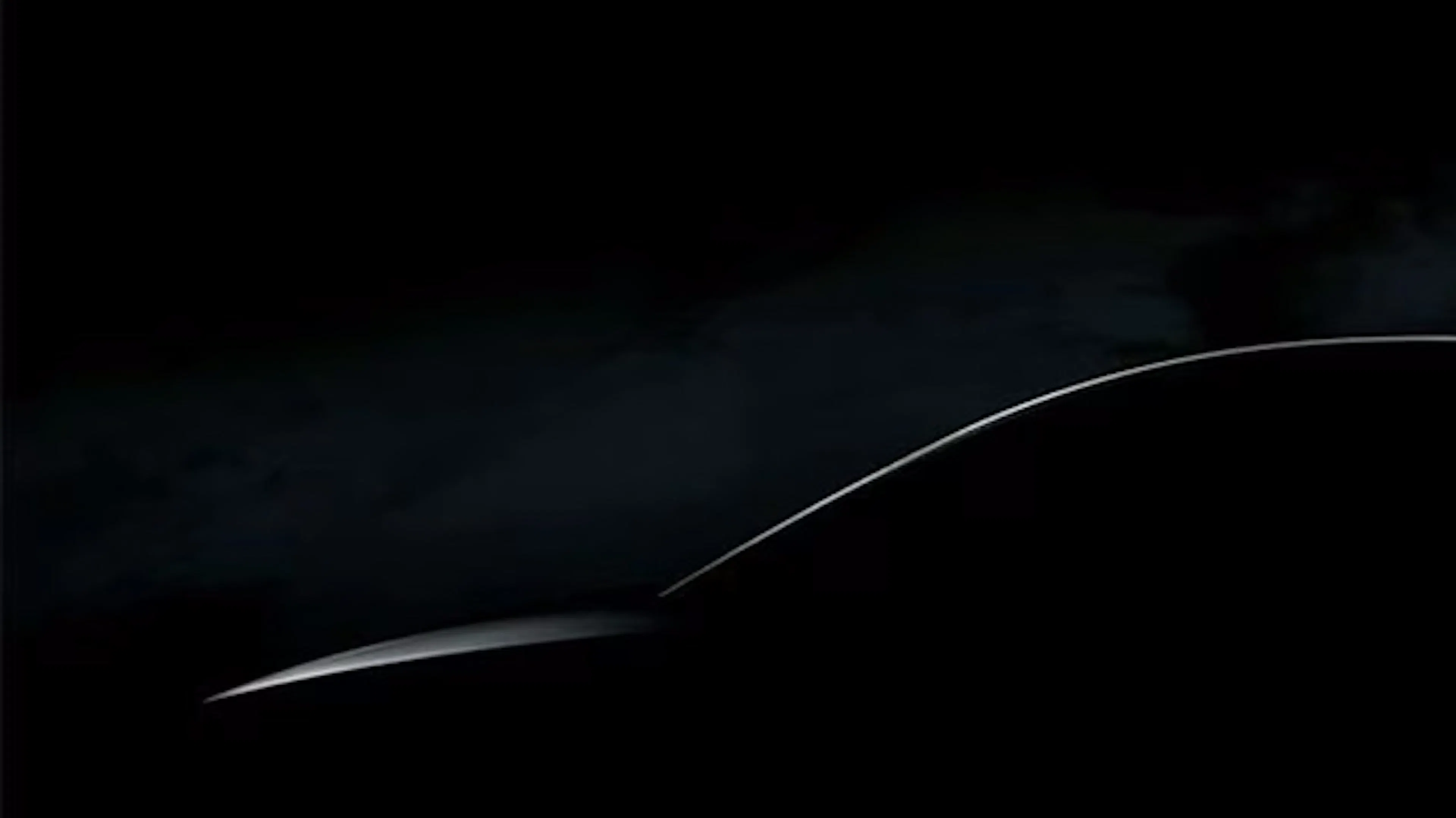 Ein schwarzes Bild mit der angedeuteten Silhouette eines Tesla.