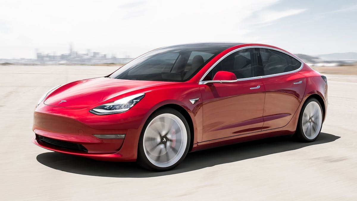 Roter Tesla Model 3 fahrend.
