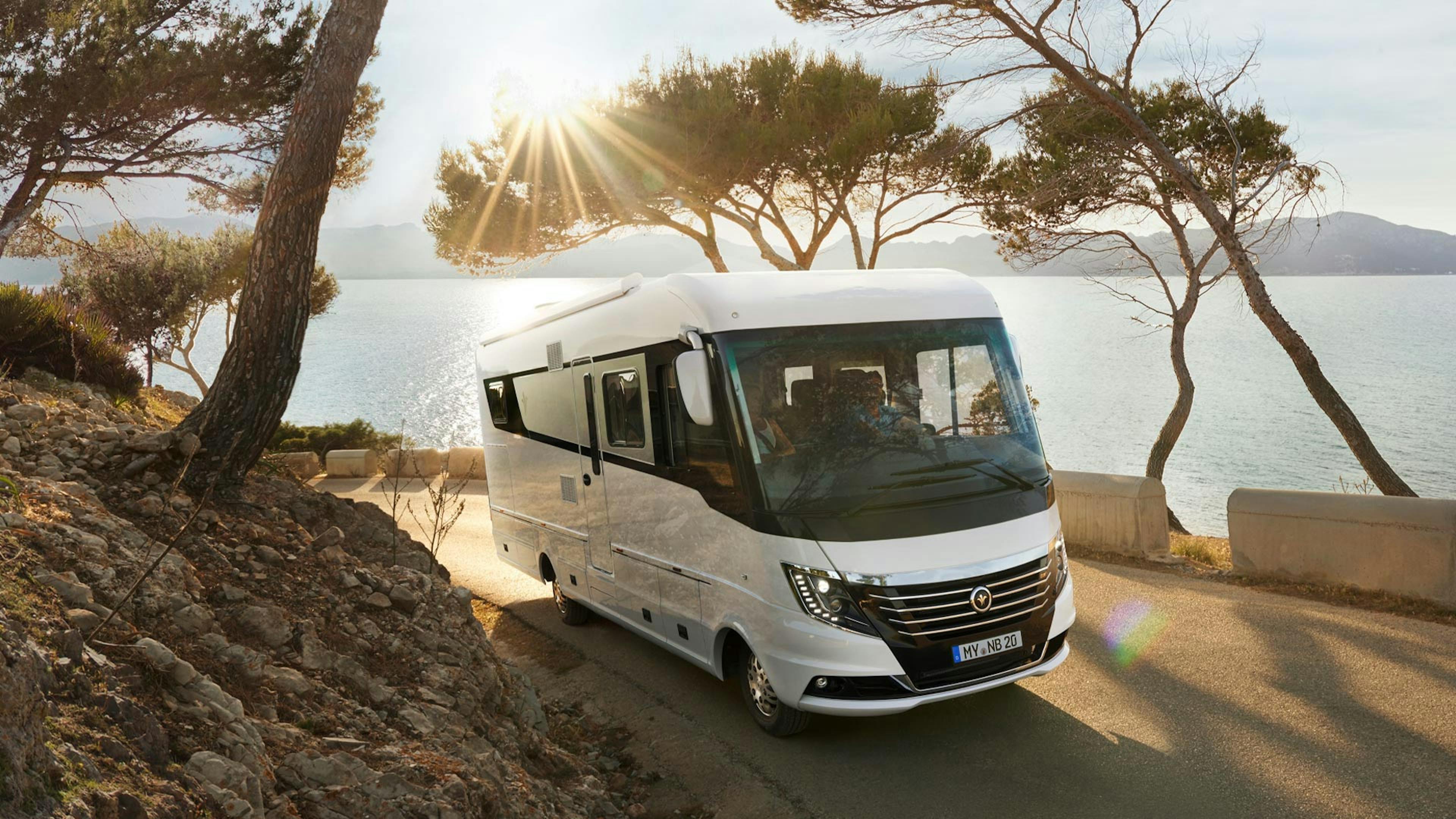 Ein Niesmann+Bischoff Flair Wohnmobil fährt eine Küstenstraße entlang.