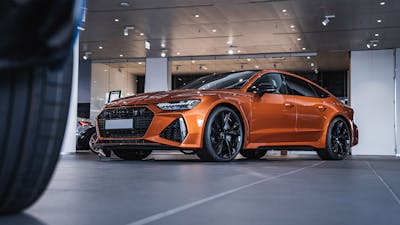 Ein metallisch glänzender Pkw steht in einem Autohaus.